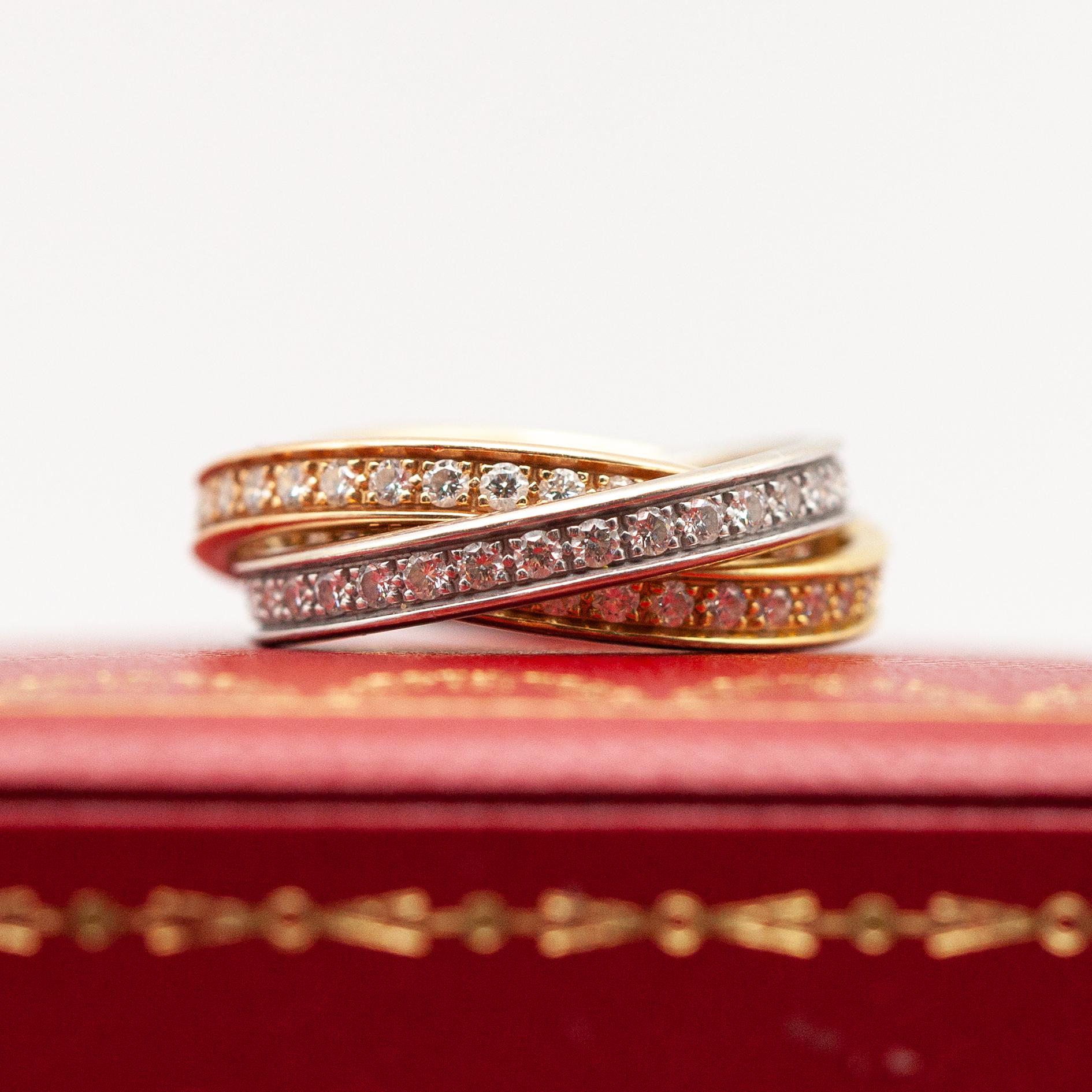 1990s Cartier Trinity 18K tri-color gold diamond rolling ring set with 99 brilliant cut diamonds approximate 1.50 carats in E-F color, VS1-VS2 clarity

Ring Size: 55  (approximate US size 7.25)

Approximate Weight: 9.70 grams
Diamonds - 1.50