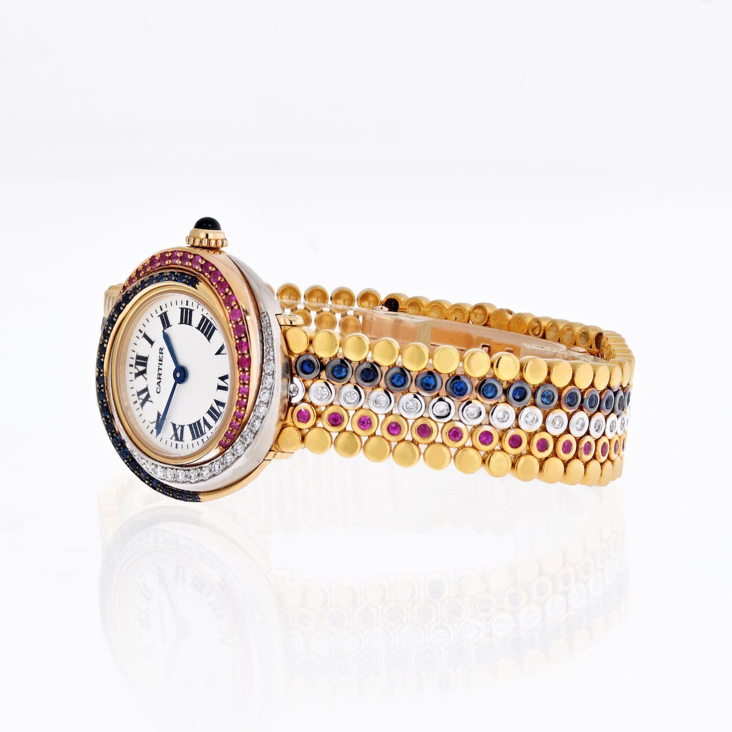 This stunning timepiece from Cartier's Trinity collection features yellow, white, and rose gold bezel spiraling gracefully towards the dial. The bezel is pave set with diamonds, sapphires and rubies. Furthermore the bracelet is bezel set with