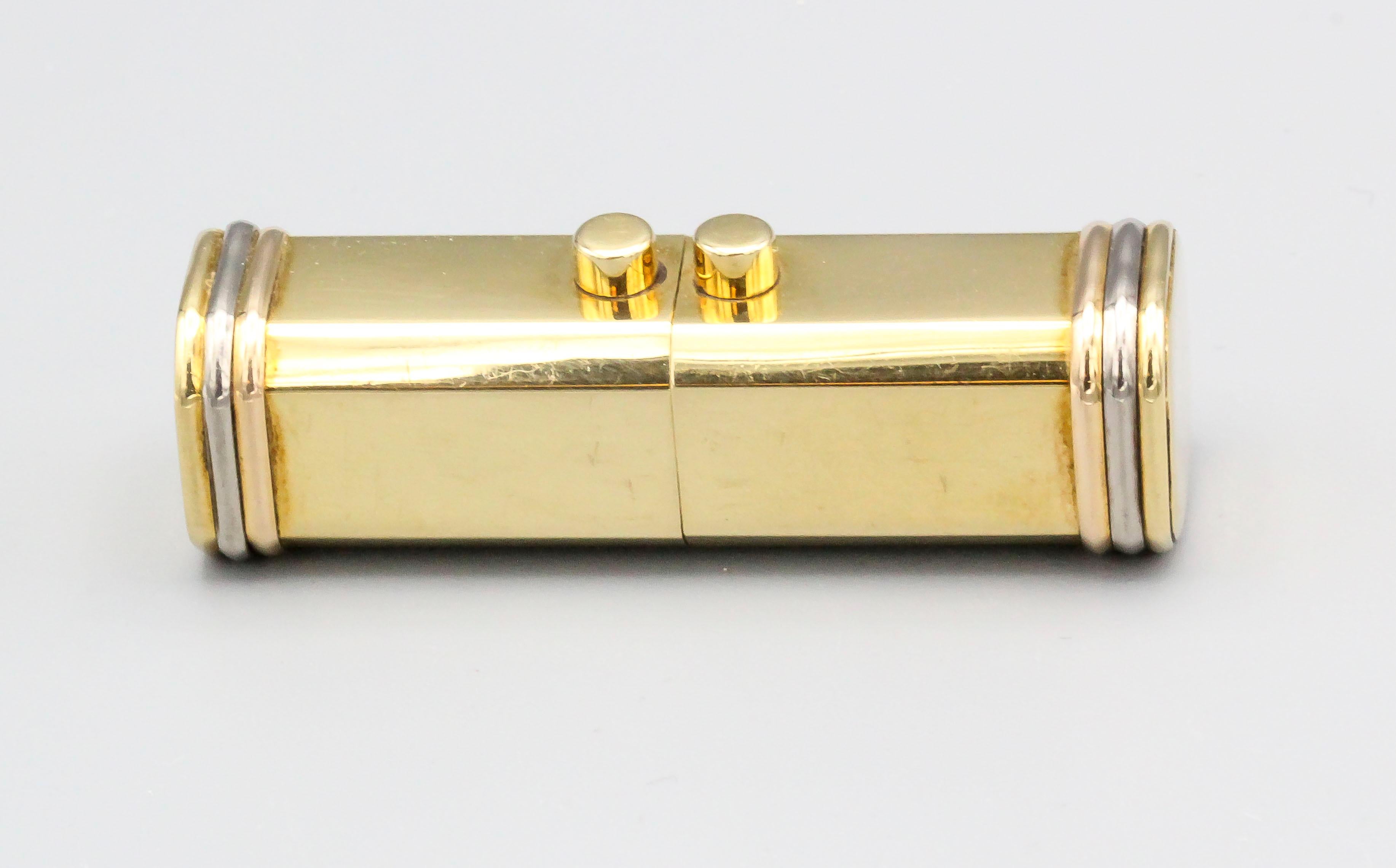 Elegant 18k yellow gold rectangular pillbox with sliding mechanism, by Cartier. It features a tri-color gold ribbed design on the sides, akin to the Trinity collection.  Well made and easy to use for larger pills.

Hallmarks: Cartier, 18K, reference