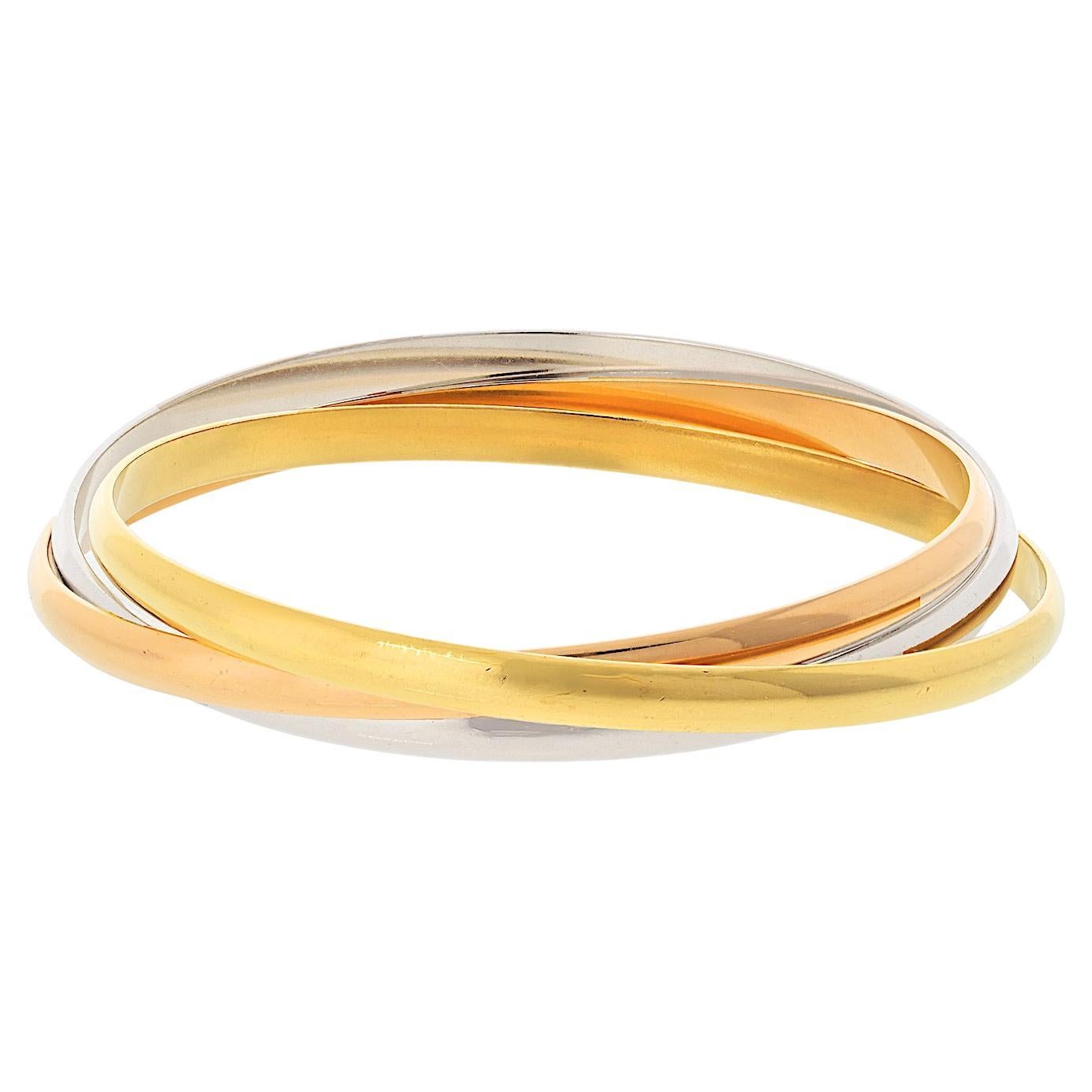 Eleganza senza tempo di Cartier con questo splendido bracciale Trinity in oro 18 carati tricolore. Simbolo perfetto di unione e stile, questo pezzo iconico presenta tre braccialetti a incastro in oro bianco, giallo e rosa, che rappresentano amore,
