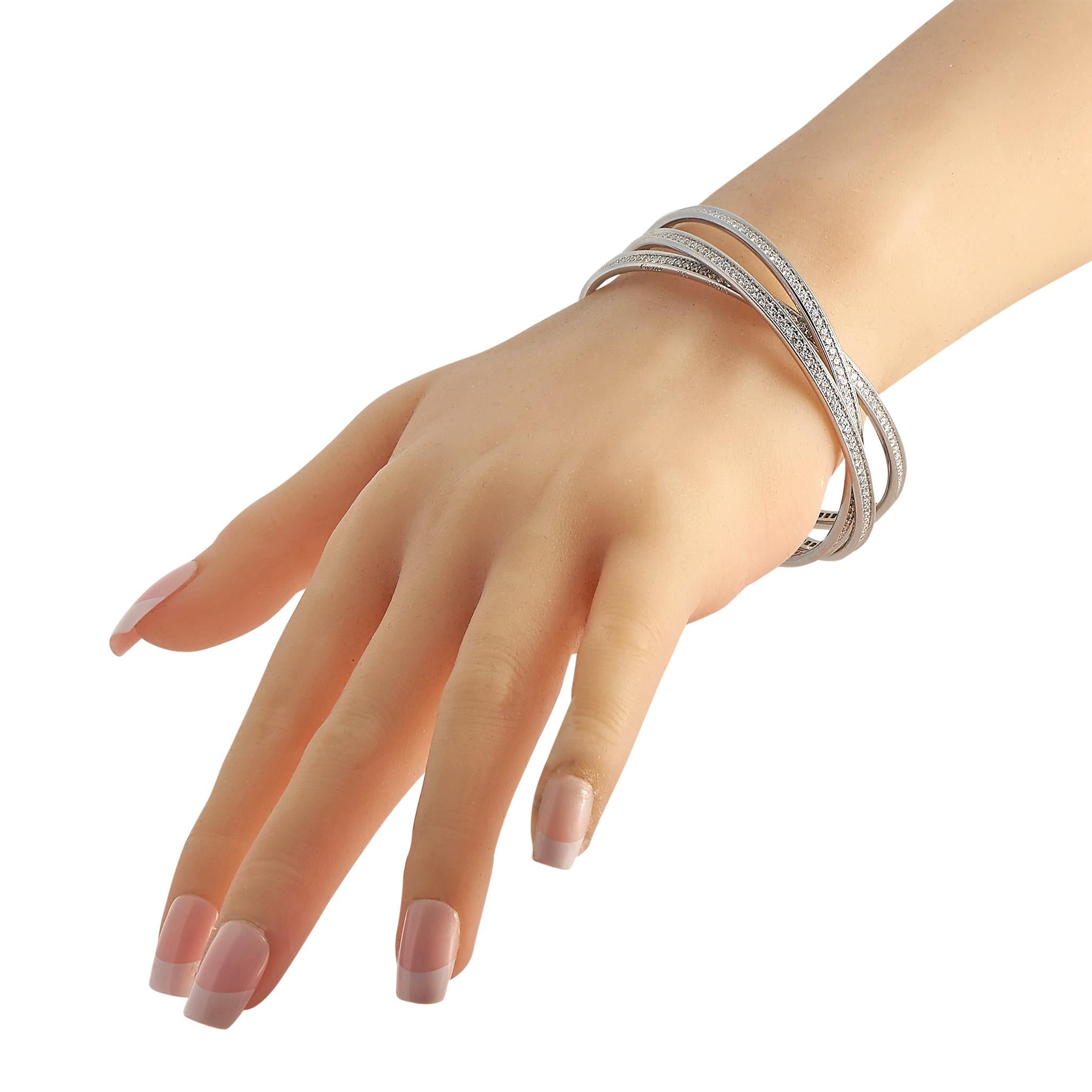 Lassen Sie Ihren eleganten Stil mit diesem Armreif von Cartier funkeln und glänzen. Es besteht aus einem Trio ineinandergreifender schmaler Armreifen aus massivem 18-karätigem Weißgold, die jeweils mit einer durchgehenden Linie aus Brillanten