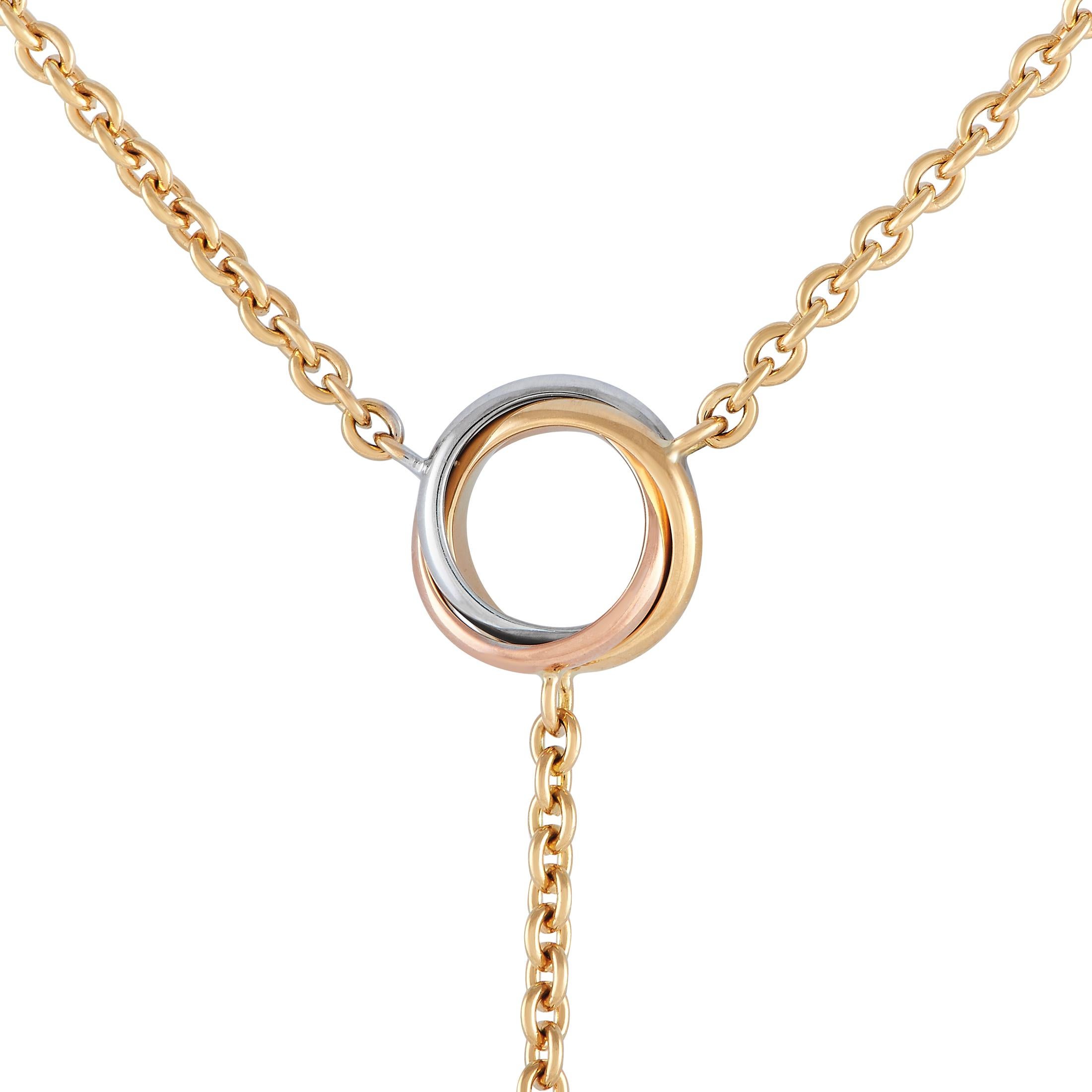Delicate and dramatic all at once, this Cartier Trinity necklace is undeniably eye-catching. A sleek 18K Yellow Gold chain measuring 14” encircles the neck, while a 0.50” round circle made from intertwined bands of 18K White Gold, 18K Yellow Gold,