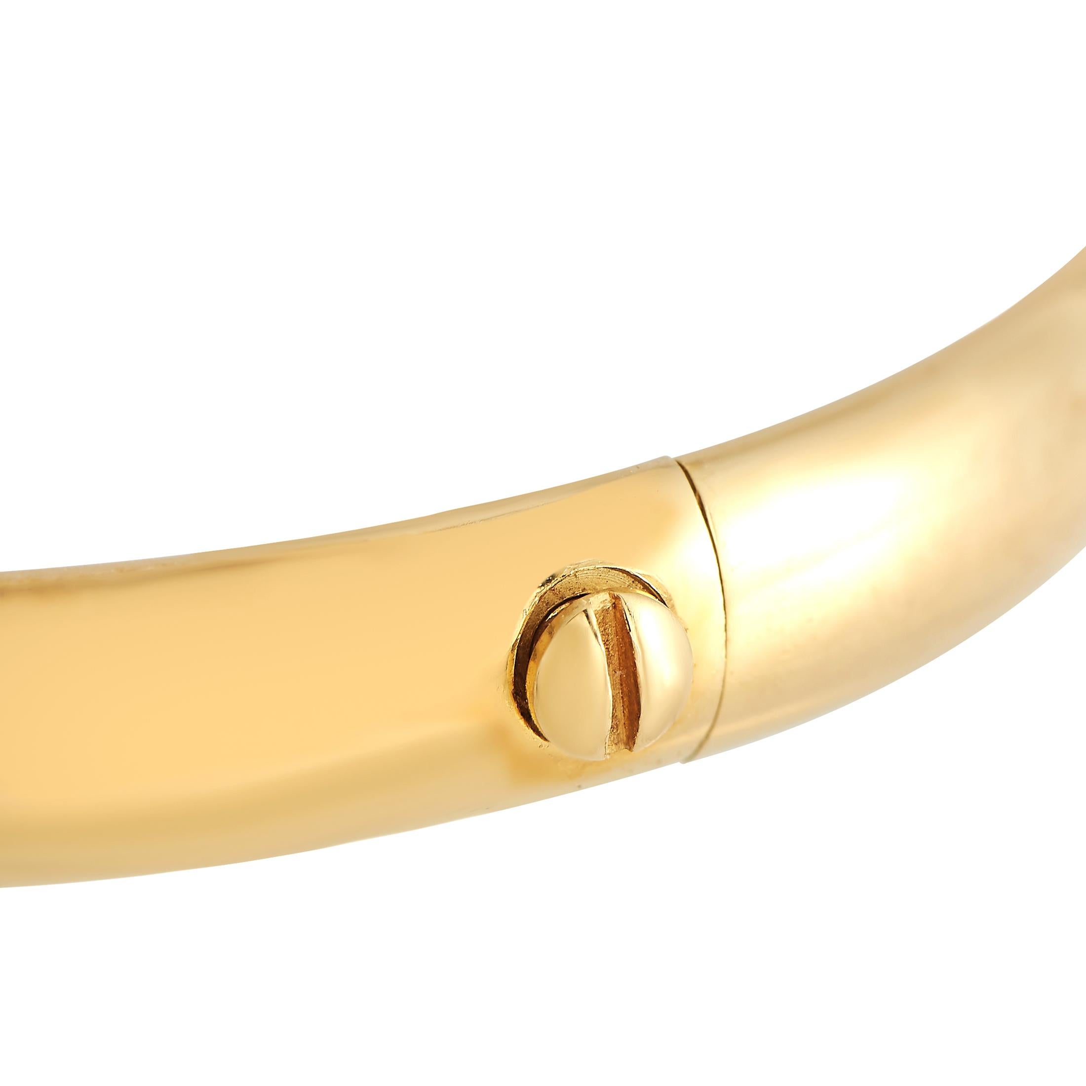 Of quiet elegance, this Cartier bangle is perfect for layering, mixing and matching. It features a rigid band in solid 18K yellow gold, detailed with cross-over fluted collars in yellow gold, rose gold, and white gold.This Cartier 18K Yellow, White