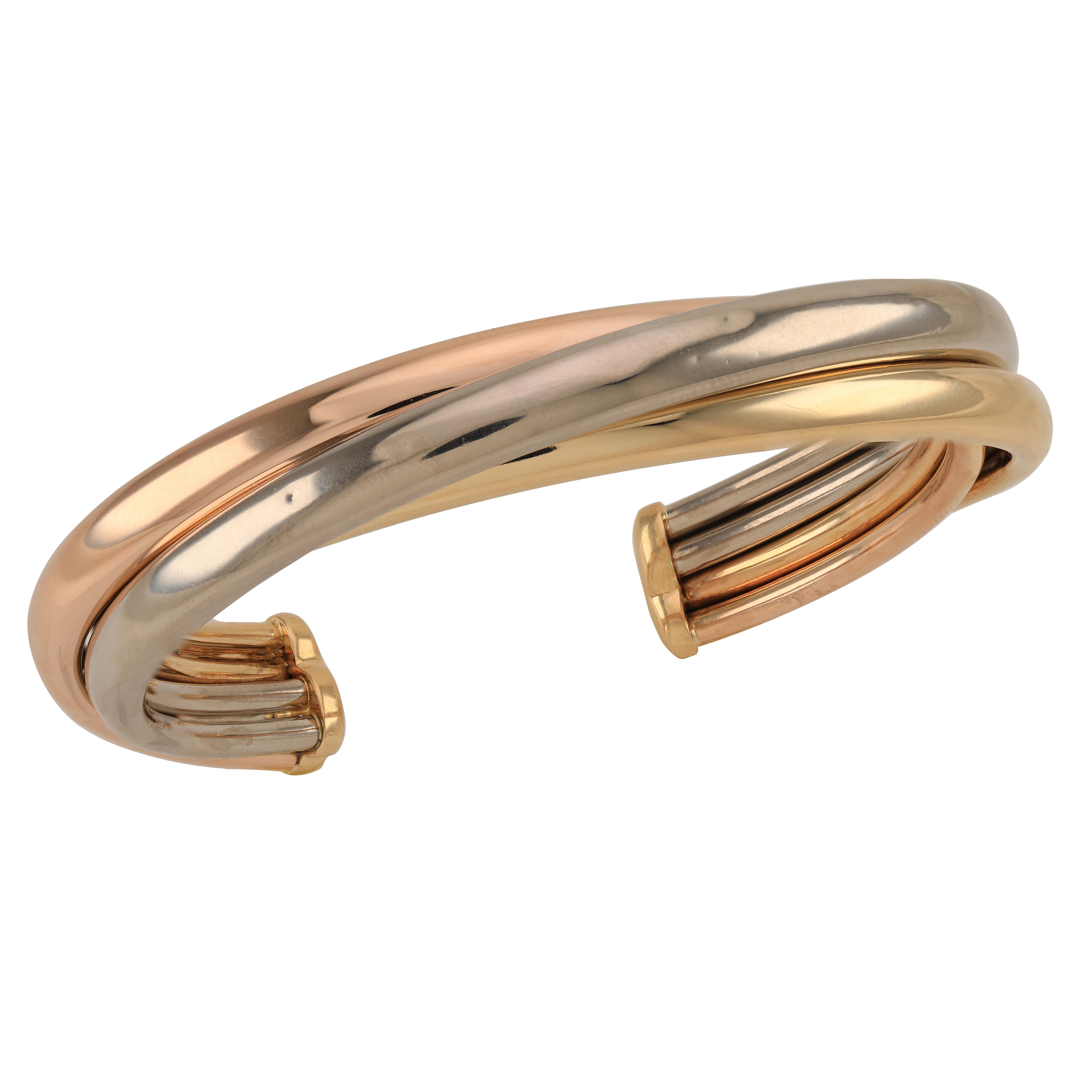 Cartier Trinity 18k Yellow White and Rose Gold Cuff Bangle Bracelet
Cartier, Circa 1992, wonderful Trinity cuff bangle bracelet made of 18k White, Yellow, Rose Gold. The beautiful bracelet is full of class, smooth and sleek twists are intertwined