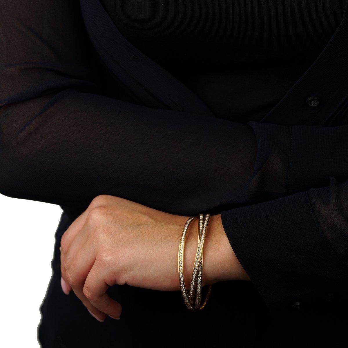 La pulsera brazalete con diamantes Cartier Trinity de oro amarillo es una expresión radiante de la artesanía y el diseño atemporal de la maison. Inspirada en la icónica colección Trinity, simboliza las tres facetas del amor: amistad, fidelidad y