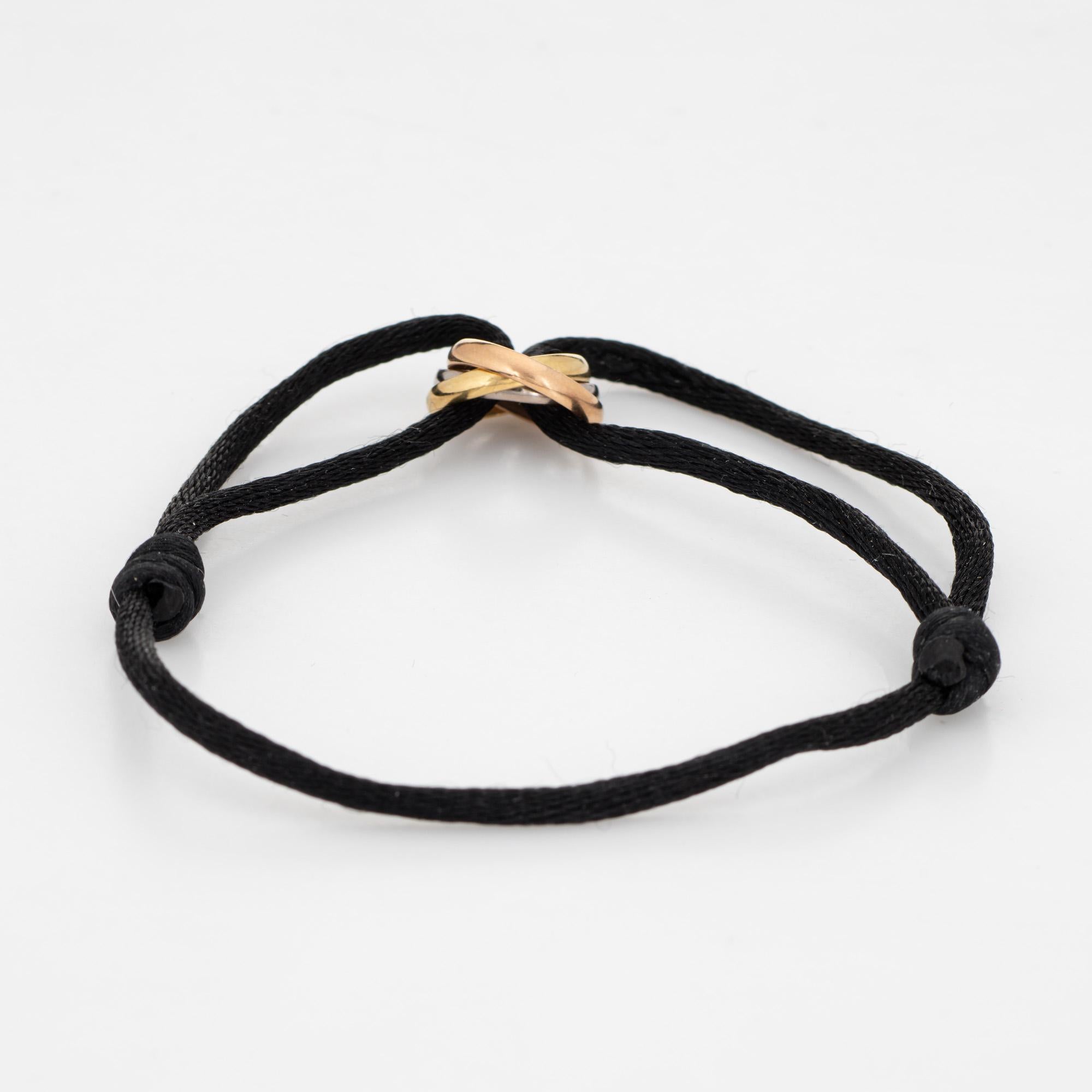
Estate Cartier Trinity bracelet crafted in 18 karat yellow, rose & white gold.  

Fitted on an adjustable black silk cord with Trinity rings in 18k white, yellow and rose gold. The bracelet is great worn alone or layered with your fine jewelry from