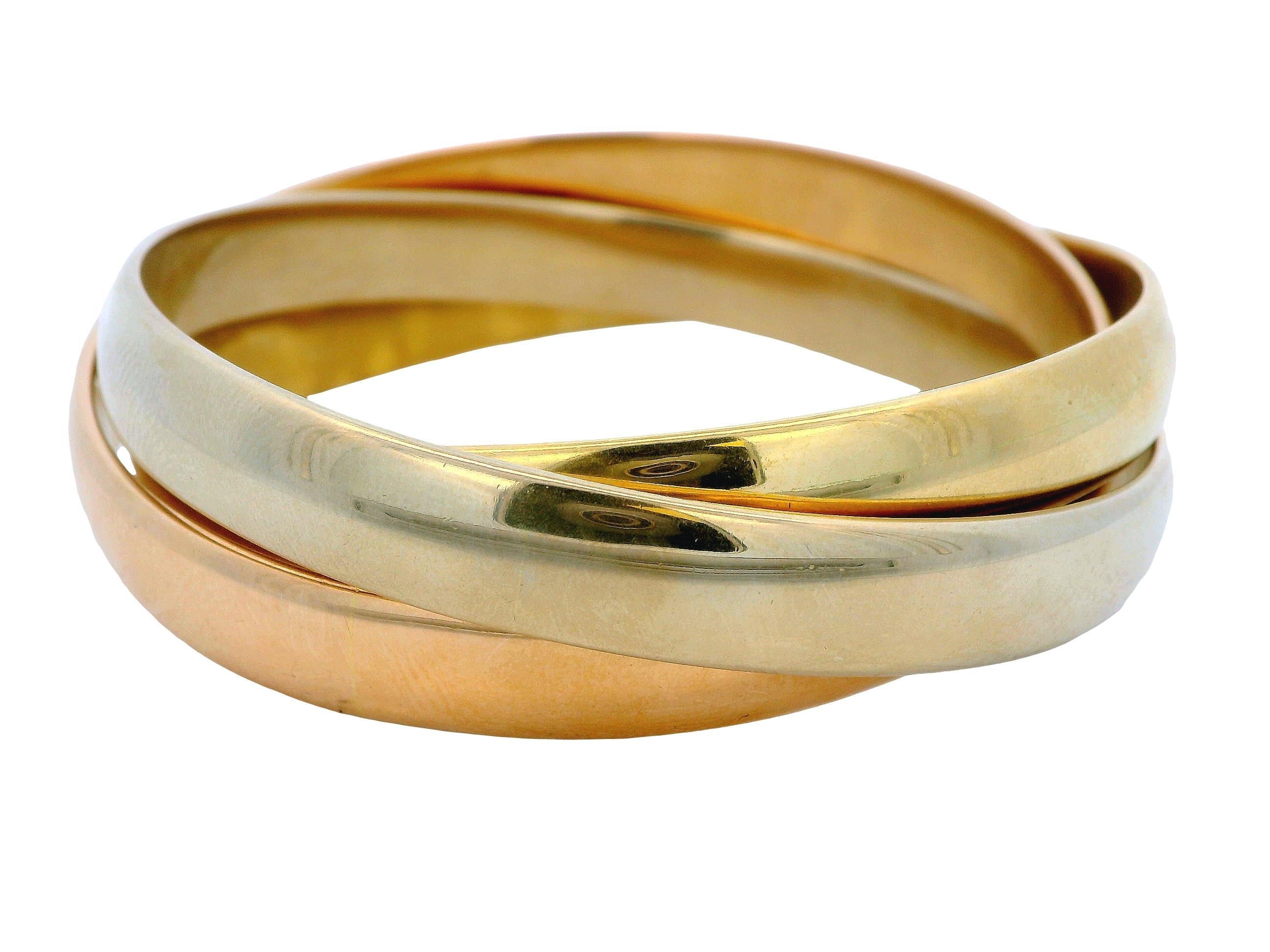 El brazalete Cartier de hacia 1980 es una hermosa pieza artesanal fabricada en Italia, con bandas entrelazadas de oro de 18 quilates en tonos rosa, blanco y amarillo. Su acabado pulido realza su lujosa calidad, mientras que el diseño entrelazado