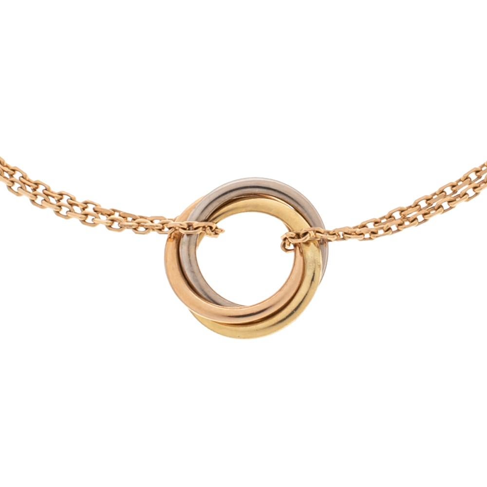 This bracelet from Cartier's Trinity collection symbolizes elegance and classic style. The 18k gold creation features chains that carry three rings made of 18k yellow, rose, and white gold. It is equipped with a lobster clasp that will help you