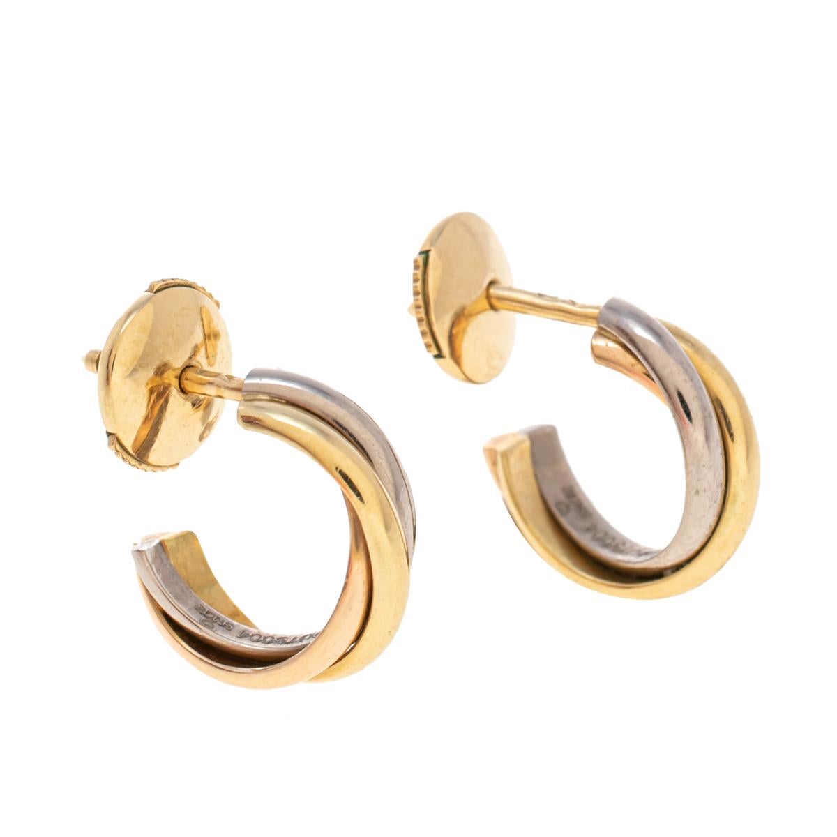Cartier earrings are timeless everyday wear. Designed in a hoop shape, these Cartier Trinity earrings feature an elegant, curved structure that beautifully wraps around your lobe and is finished with omega earrings back. They are made of 18K