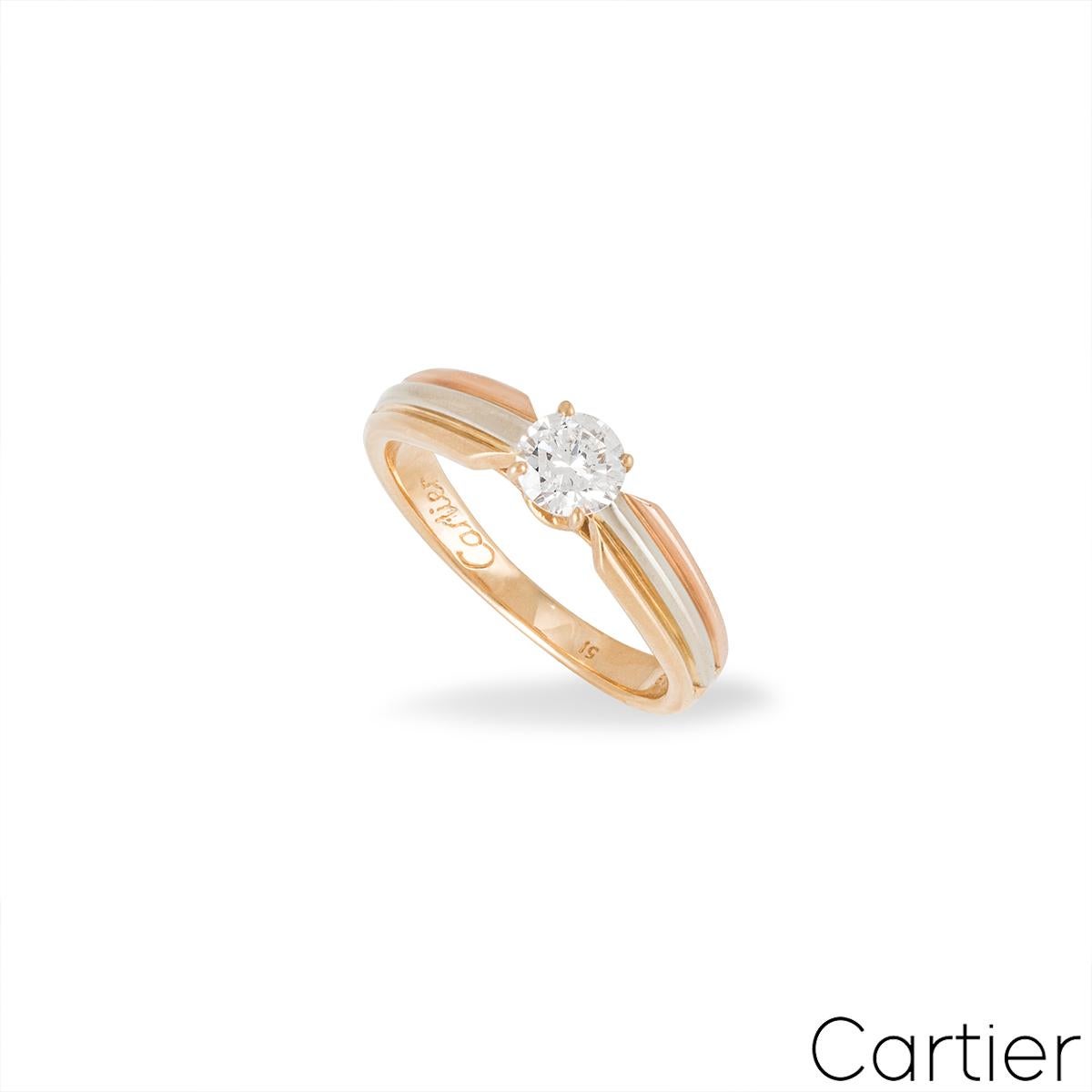 An 18k tri-colour gold diamond ring from the Trinity de Cartier collection. The ring is set to the centre with a 0.32ct round brilliant cut diamond, D colour and VVS2 in clarity. The diamond is set within a classic 4 claw setting with the band