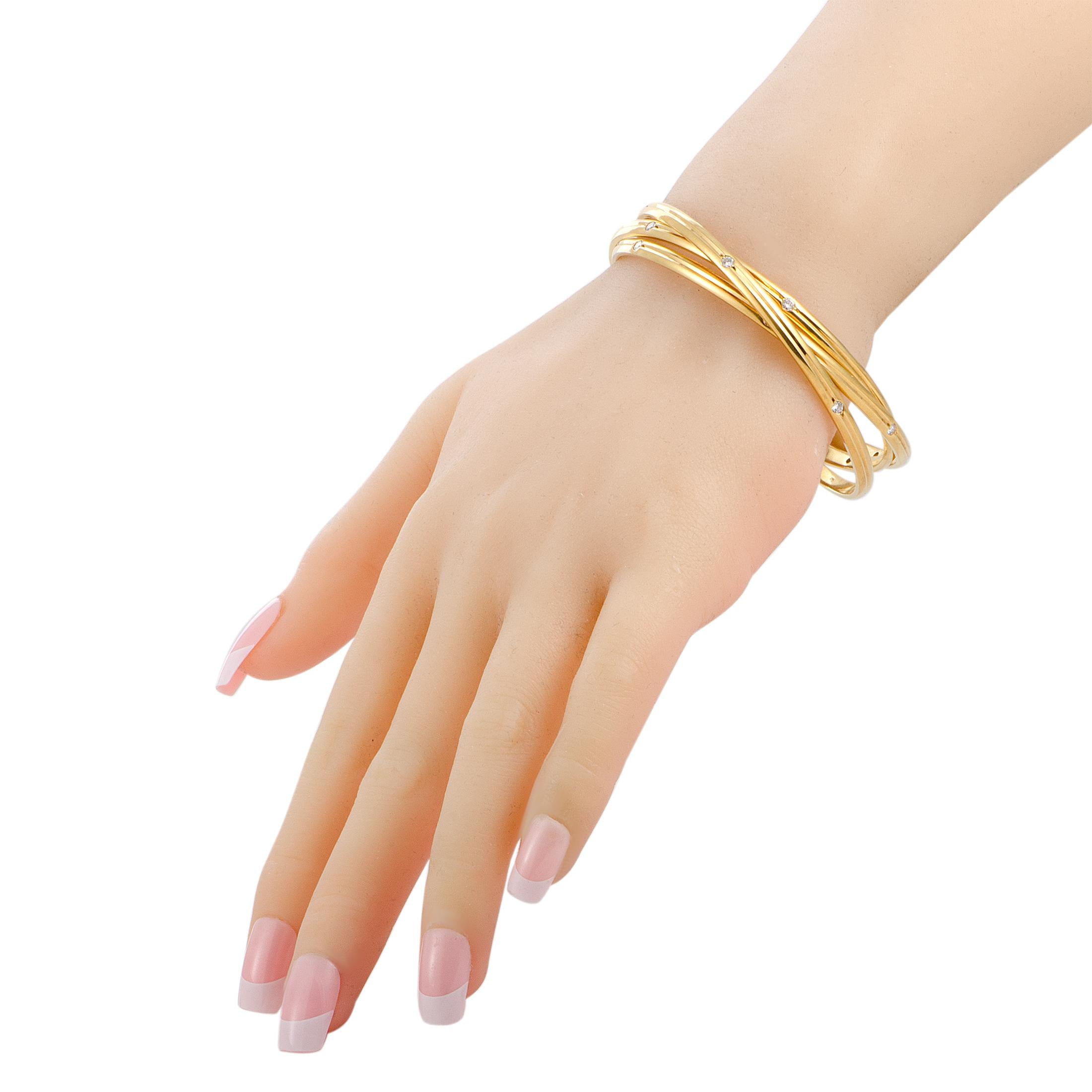 Presented within the renowned “Trinity” collection, this sublime Cartier piece includes three gorgeous bangle bracelets that are tastefully decorated with scintillating diamonds. The bangles are expertly crafted from luxurious 18K yellow gold and