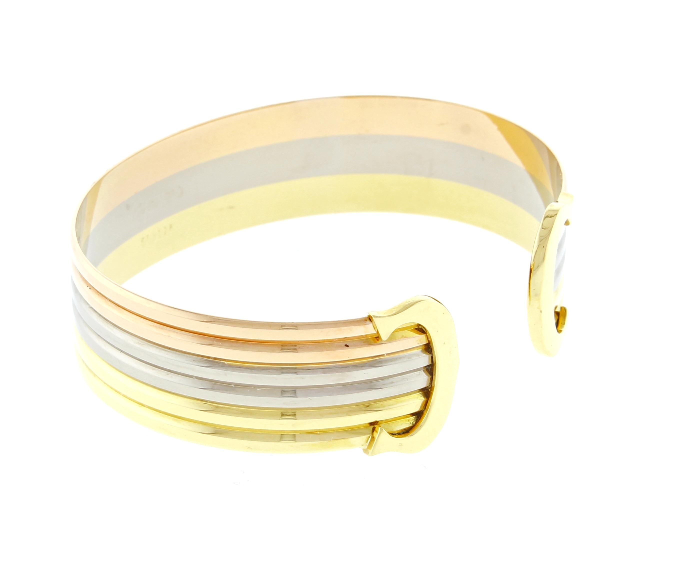 From Cartier, their iconic double C de Cartier decor trinity bracelet. Crafted from white, yellow and pink 18 karat gold. 5/8 of an inch wide,  Medium size