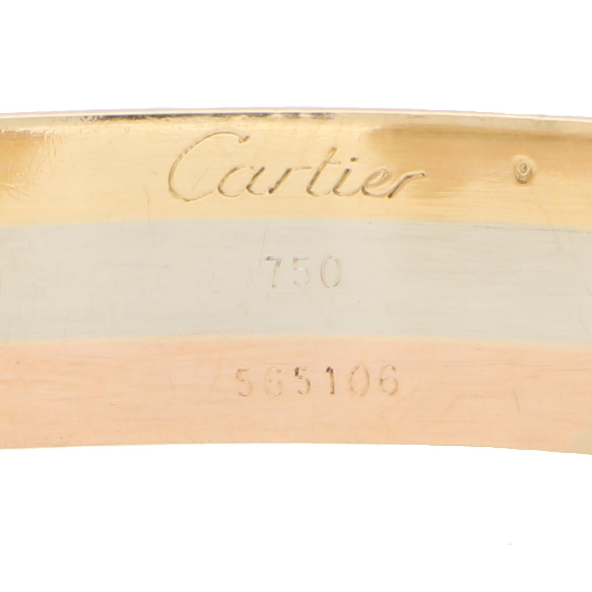A classic Cartier trinity double C bangle set in 18k rose, white and yellow gold. 

The bangle is designed as a torque and is made of three solid soldered tricoloured bands. To either end of the bangle we see the iconic Cartier C in yellow gold.