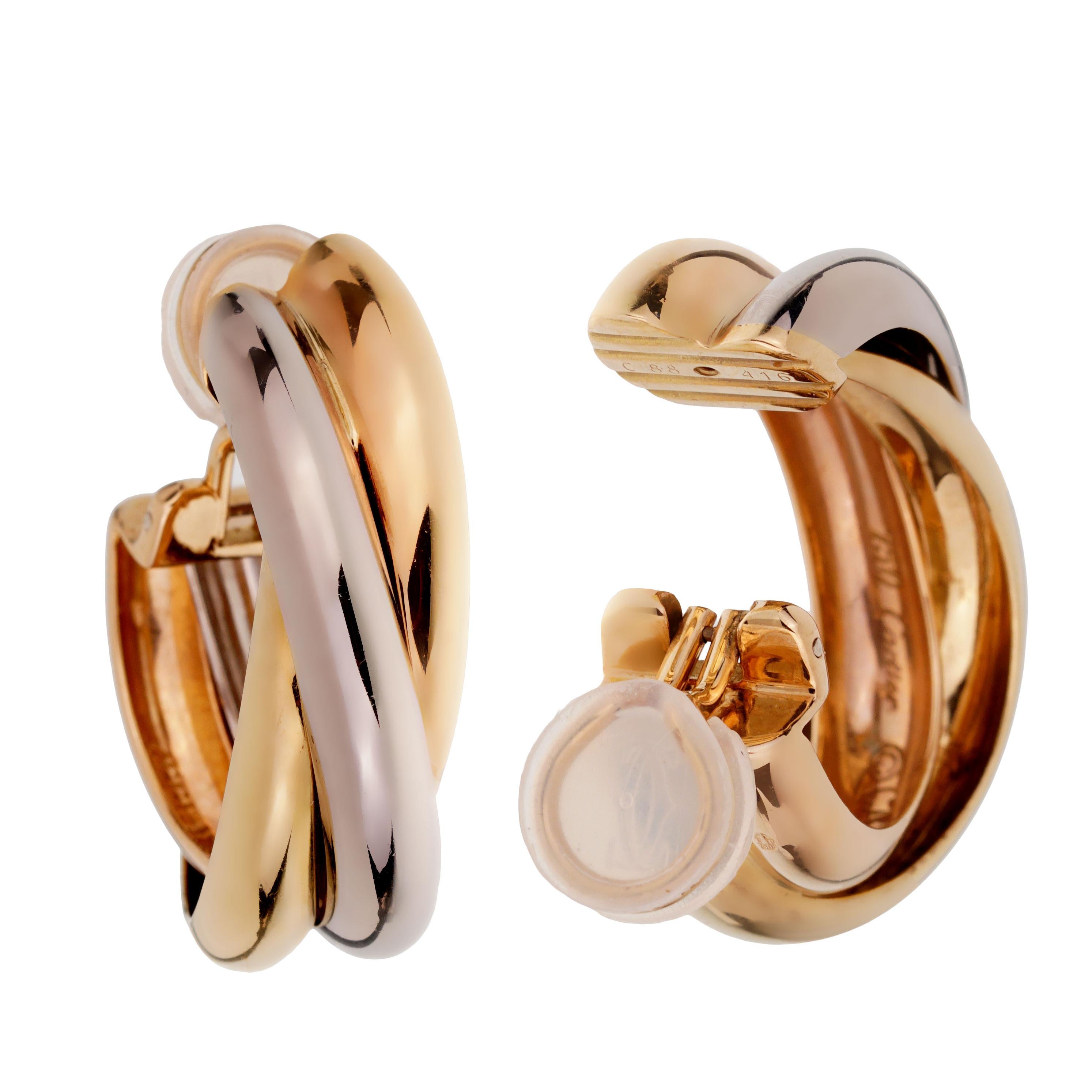 These classic extra-large clip-on earrings from Cartier's Trinity collection feature three elegantly intertwined bands made in 18k yellow, white and rose gold.

Length: 1.18