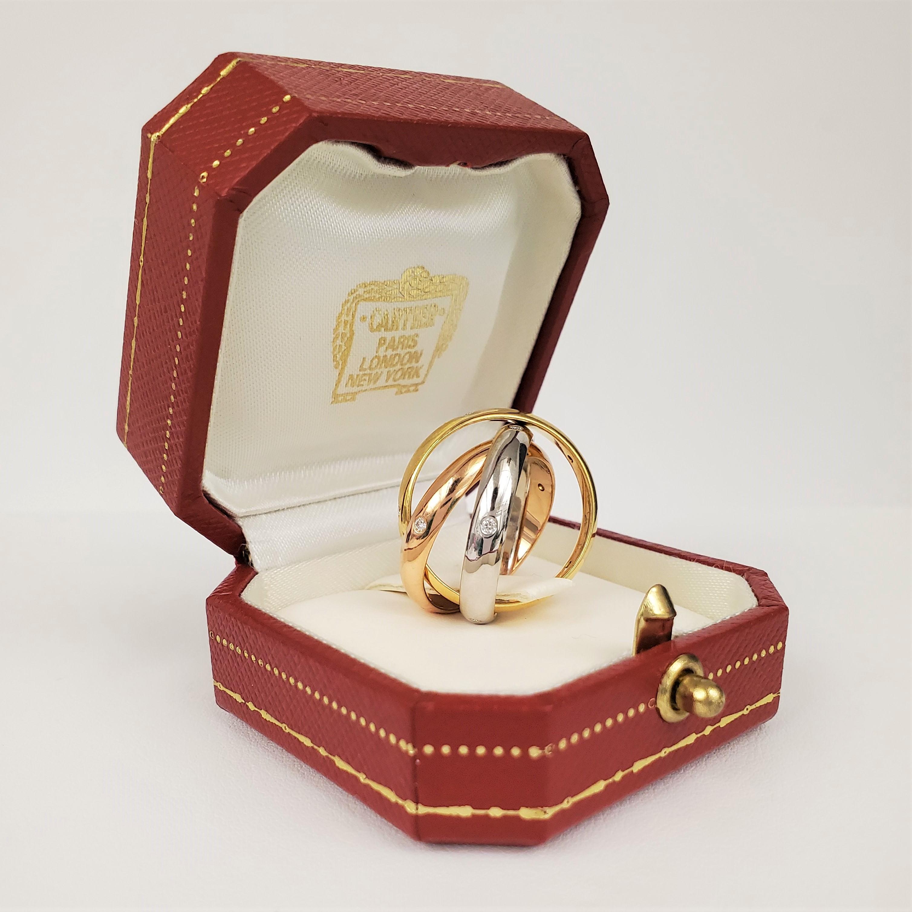 Authentic Cartier Ring crafted in 18 karat white, yellow, and pink gold.  Each band is set with 5 round brilliant cut diamonds for an estimated .15cttw. Signed Cartier, 75, 55, with serial number.  Size 55, US size 7 1/4.  Ring is presented with