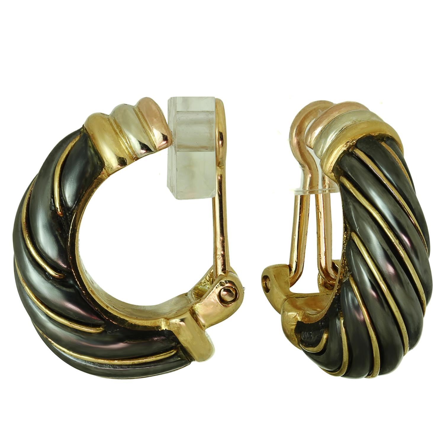These gorgeous Cartier clip-on earrings are from the iconic Trinity collection and feature a wrap design crafted in 18k yellow, white, and rose gold and set with hematite. Made in France circa 1990s.  Measurements: 0.31