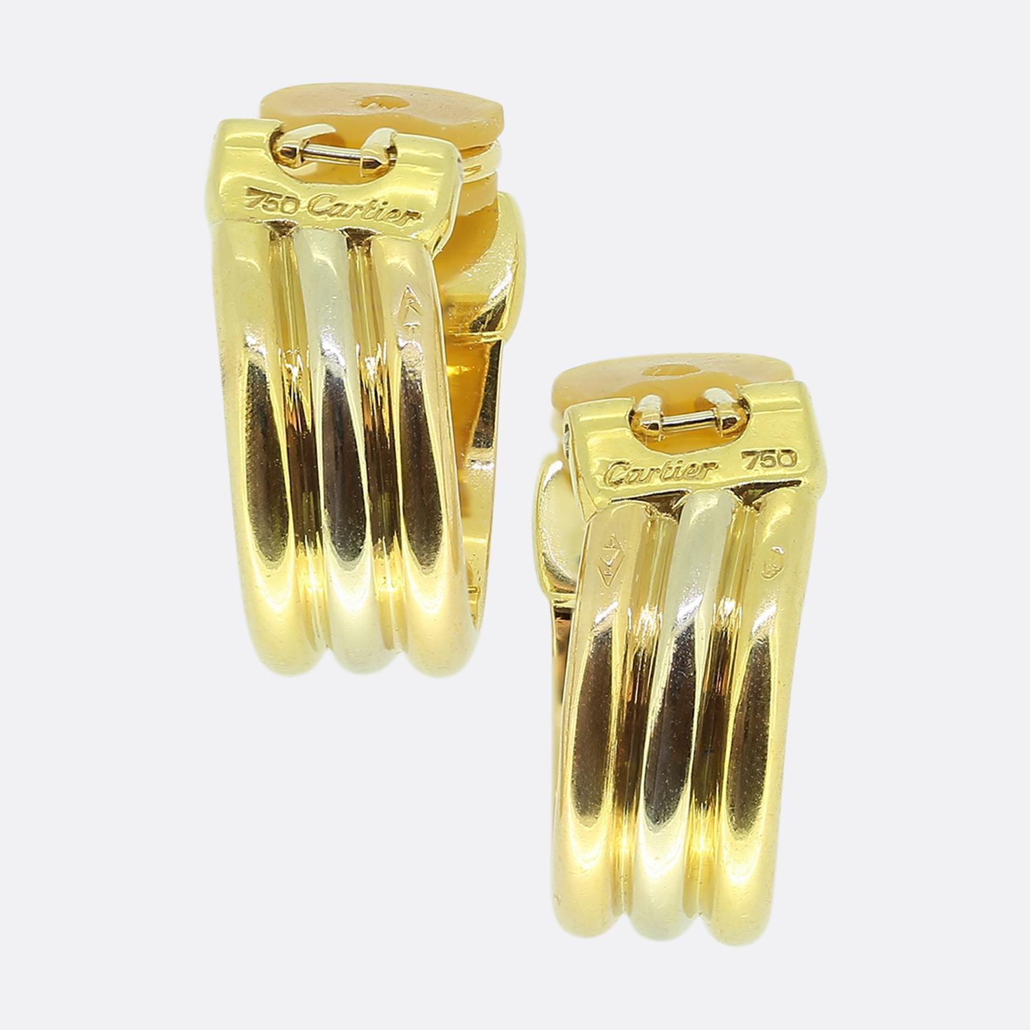 Here we have a stylish pair of hooped earrings from the world renowned luxury jewellery house of Cartier. These earrings are crafted from 18ct gold, featuring a sleek, triple-bar design in yellow, white and rose gold. Each earring is accented with a