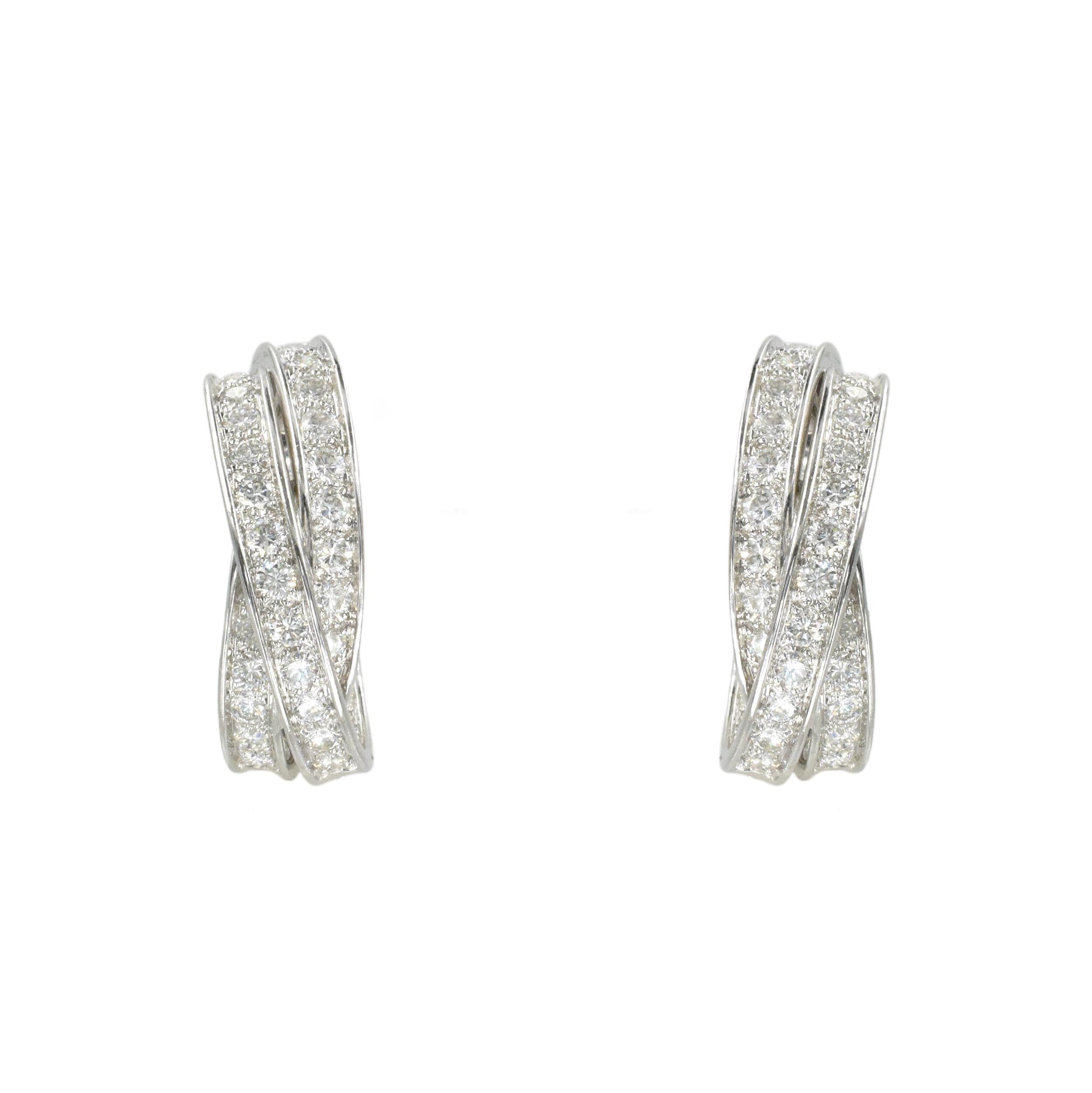 Cartier Trinity Inside Out Diamond Ear-clips In 18k White Gold. This pair of hoops feature three
interlocking bands design set with round brilliant cut diamonds with a total weight of
approximately 5.0 carats Color: F/G, Clarity: VS+. Crafted in 18k