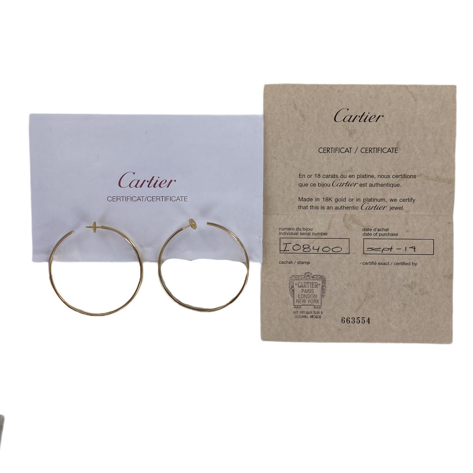 Cartier's popular Trinity hoops fashioned in 18 karat white, yellow, and rose gold. The large hoop earrings measure 2.25 inches in diameter, are light weight, and feature Cartier's original La Pousette backs. The earrings are signed Cartier 750,