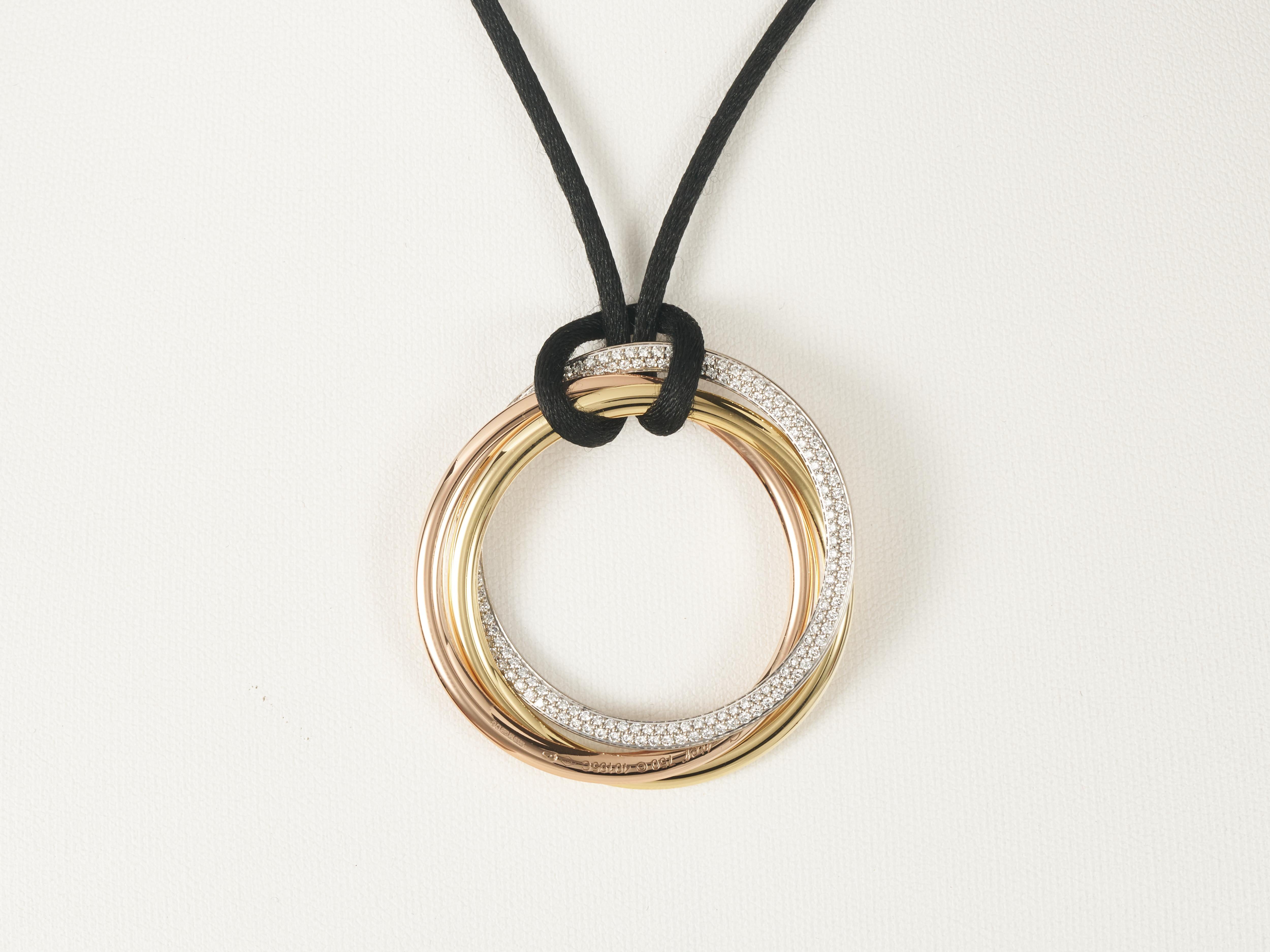 Cartier 
Collier Trinity Looping 
Pendentif sur Corde

Grande taille


Le pendentif est composé de trois anneaux reliés entre eux en or jaune, rose et blanc 18 carats. 

Un côté de la bague en or blanc est entièrement pavé de 175 diamants naturels
