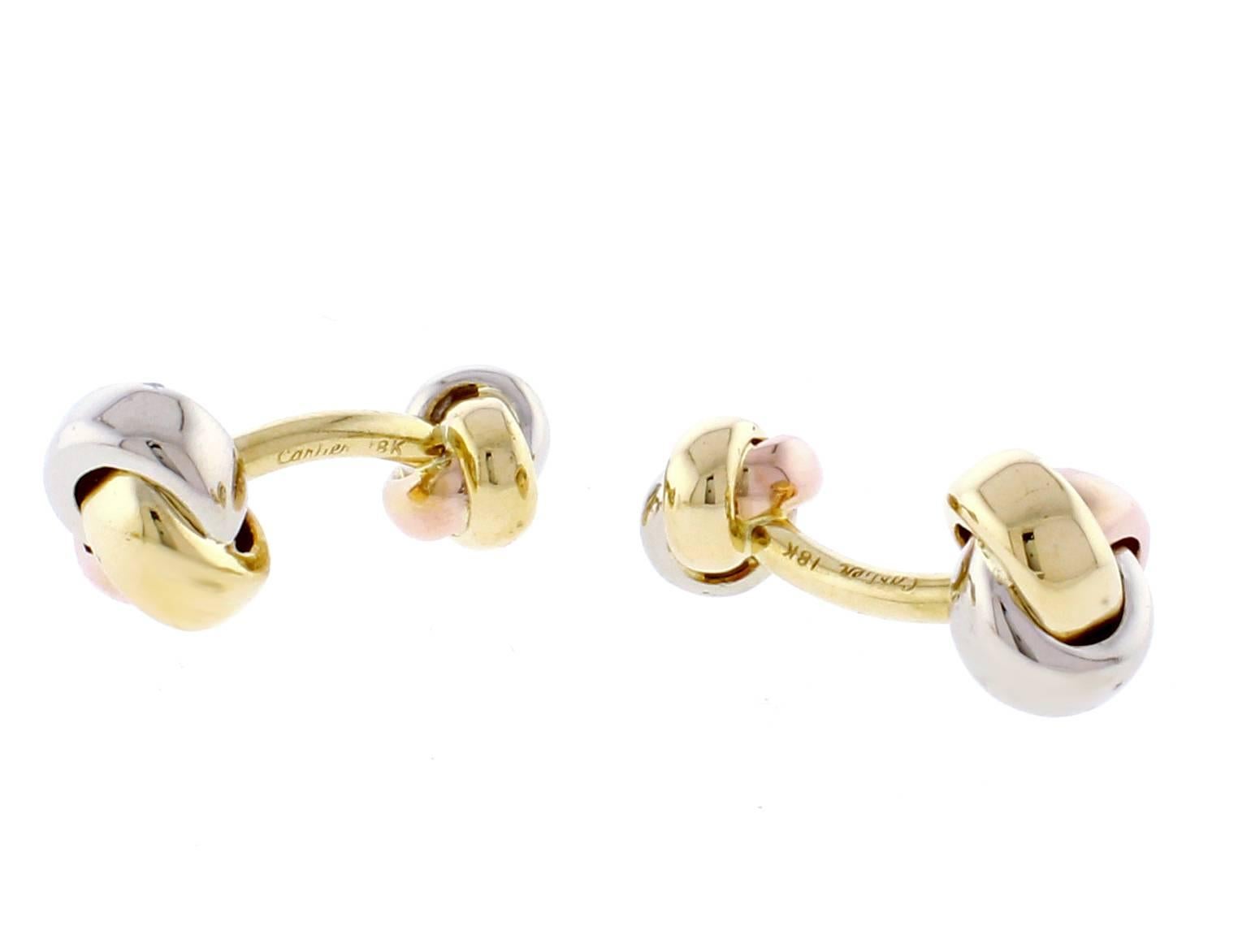 From Cartier's iconic trinity collection, a pair of love know cufflinks. Two knots of  18 karat white, yellow and pink gold form this classic cufflink design..
