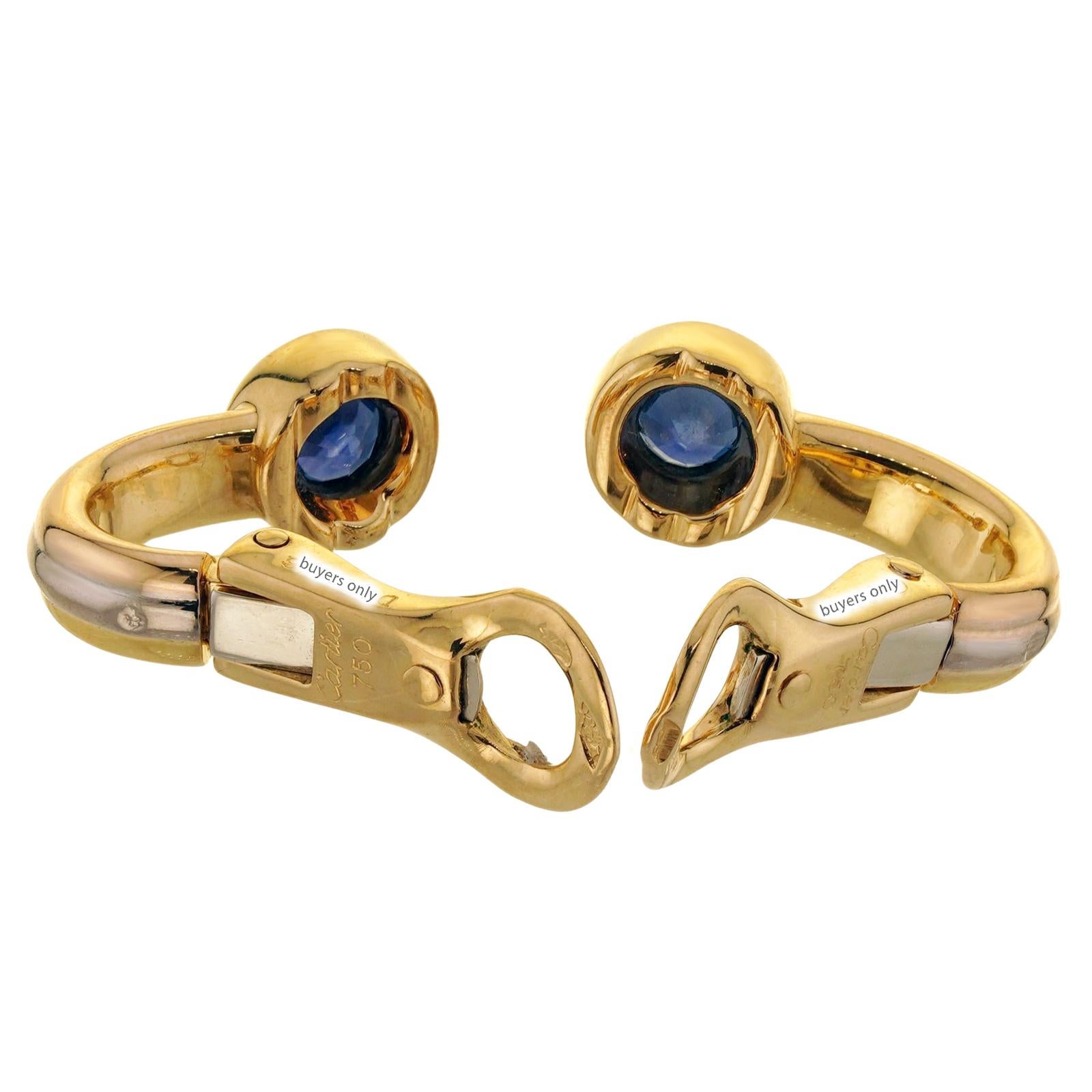 These gorgeous Cartier earrings from the classic Trinity collection are crafted in 18k yellow, white, and rose gold and set with round bright blue sapphires. Made in France circa 1995. Measurements: 0.23