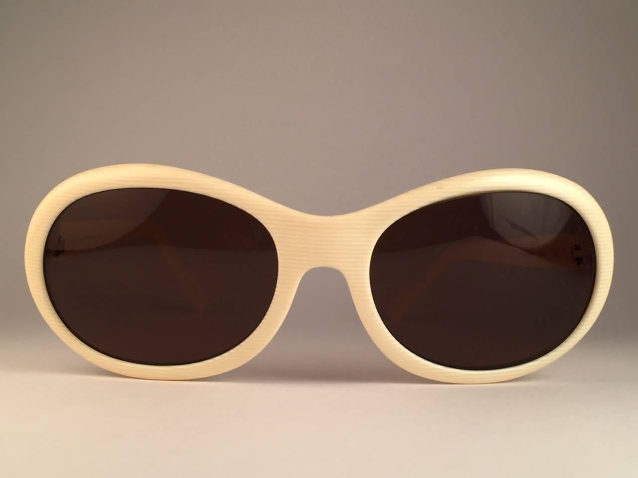 New Cartier Trinity Sunglasses with brown (uv protection) lenses. 
Frame is ivory and has the famous real gold and white gold accents. All hallmarks. Both arms sport the famous gold Trinity sign from Cartier on the temple. These are like a pair of