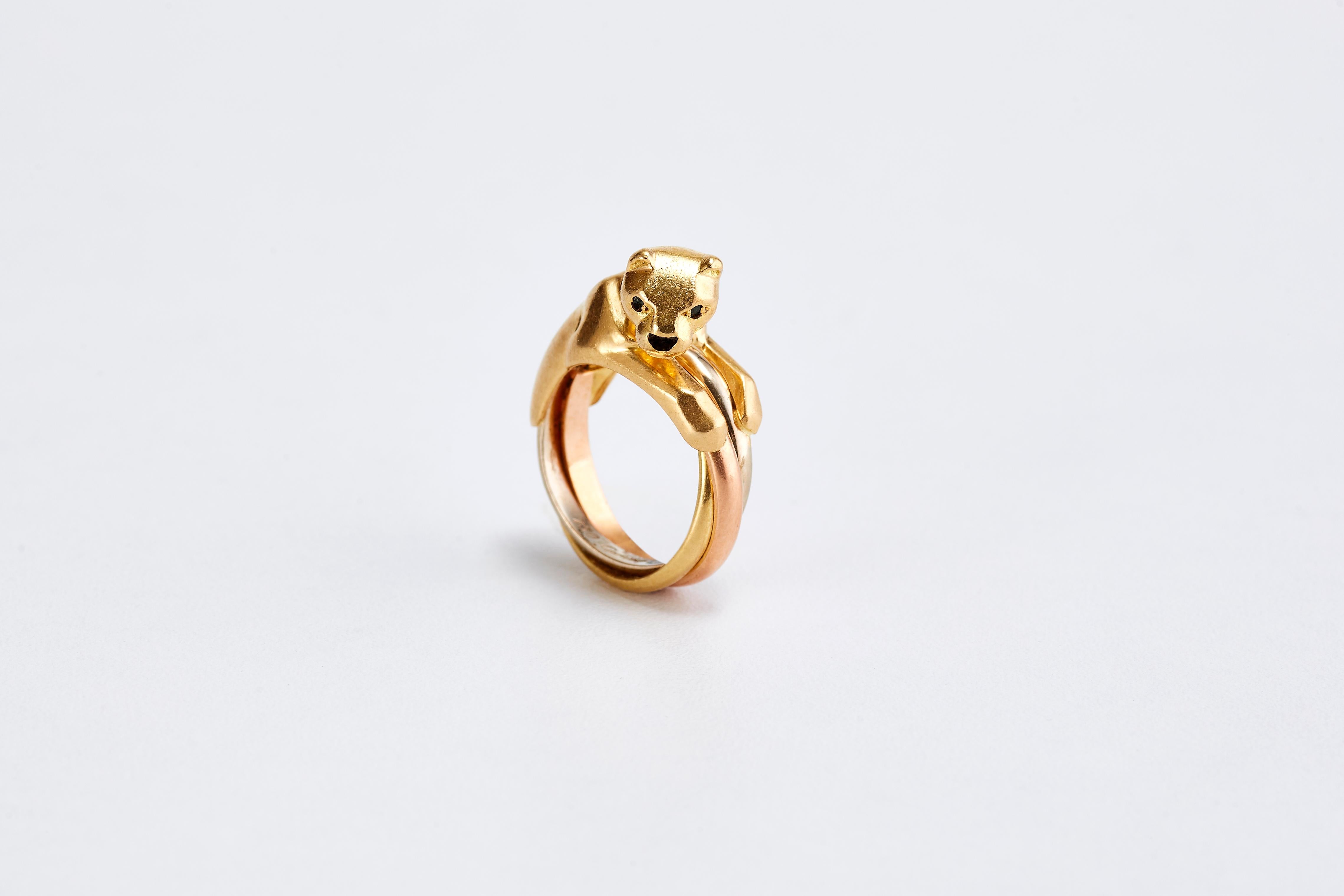 Cartier Trinity Panther Ring in yellow gold with sapphire eyes and onyx nose. 
High fashion and very in style these days.
Made in France, circa 1990s. From the iconic panther series of Cartier.
Total Weight: 11.60 grams. Ring size: 47 Europe.
