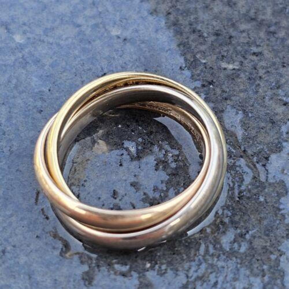This Cartier Trinity Ring Band Rolling is a stunning piece of fine jewelry that will surely catch anyone's eye. Made of 18k multi-tone gold, this ring is both pink, yellow, and white in color, giving it a unique and elegant look. Its style is a