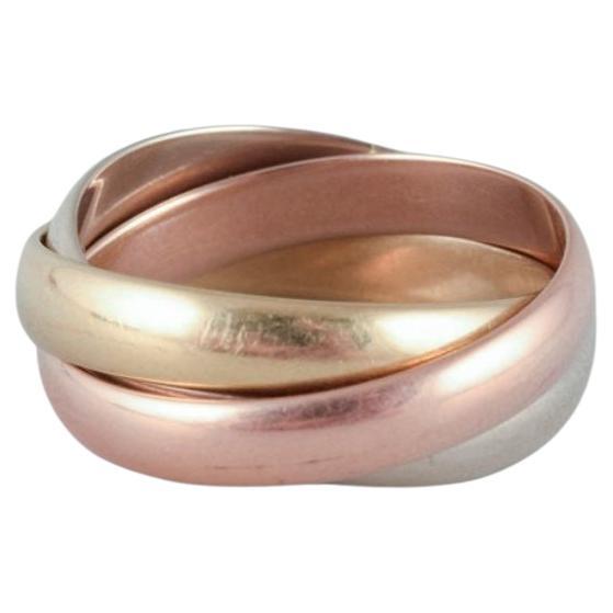 Cartier "Trinity" ring in 18 karat gold, white gold, and rose gold. 