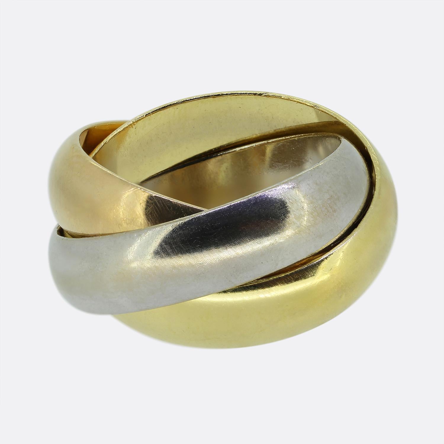 Aquí tenemos una pieza clásica de la mundialmente conocida casa de joyas de lujo Cartier. Este anillo presenta tres bandas entrelazadas de oro de 18 ct: amarilla, blanca y rosa; la rosa lleva grabada la palabra 