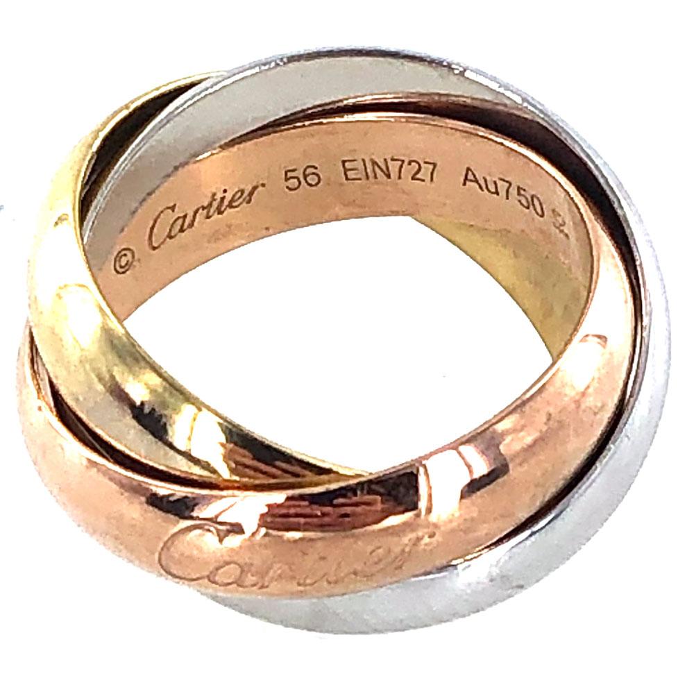 Authentic Cartier Trinity Rolling Ring well crafted in 18 karat yellow, white, and rose gold. Each of the three interlaced bands measures 5.2mm in width. The rose gold band features the Cartier signature, size 56, serial number (EIN727), and Au 750.