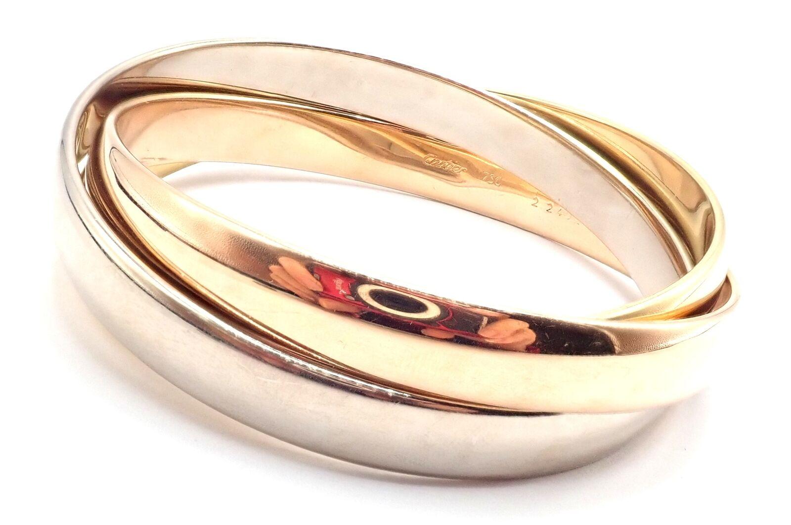 Bracelet en or tricolore 18k Trinity Rolling Large Model Bangle by Cartier. 
Détails :
Longueur : Taille moyenne (17cm)
Chaque largeur de bracelet : Chaque : 9mm
Ensemble : 24 mm au plus large
Poids : 89 grammes
Poinçons estampillés : Cartier AU 750