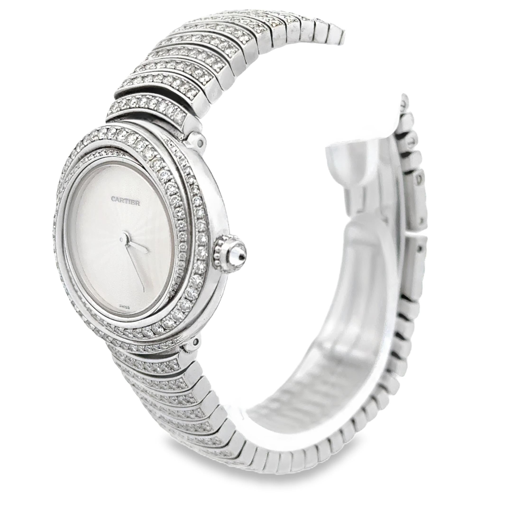 An elegant ladies' watch created by Cartier from the Trinity collection, featuring a round dial with a spiral bezel accented by round brilliant cut diamonds and a bracelet that is further adorned with more round cut diamonds. Finely made with 18K