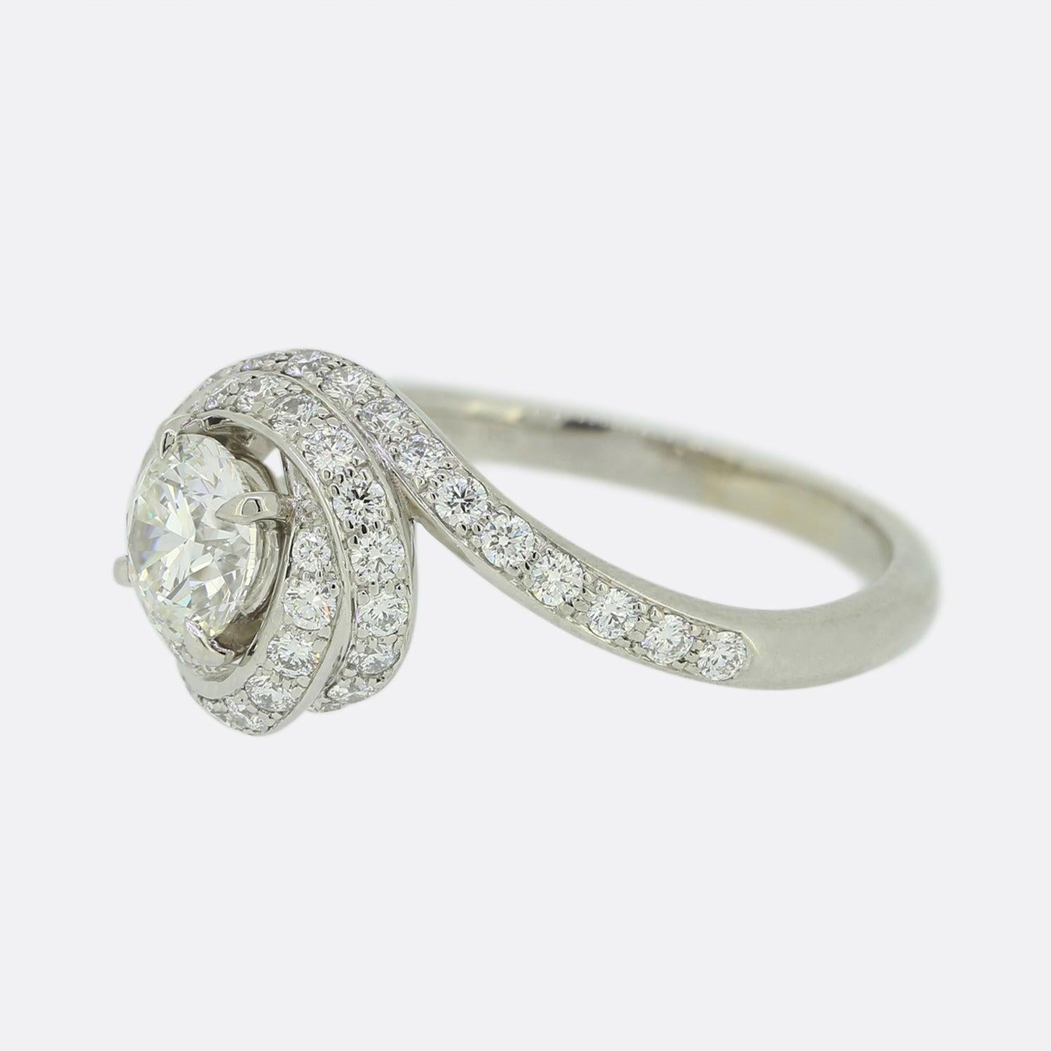 Here we have an iconic ring from the world renowned jewellery house of Cartier. With this particular piece, Cartier's Trinity symbol has been re-worked into a bejewelled ribbon around the main stone. On a beautiful platinum band sits a large