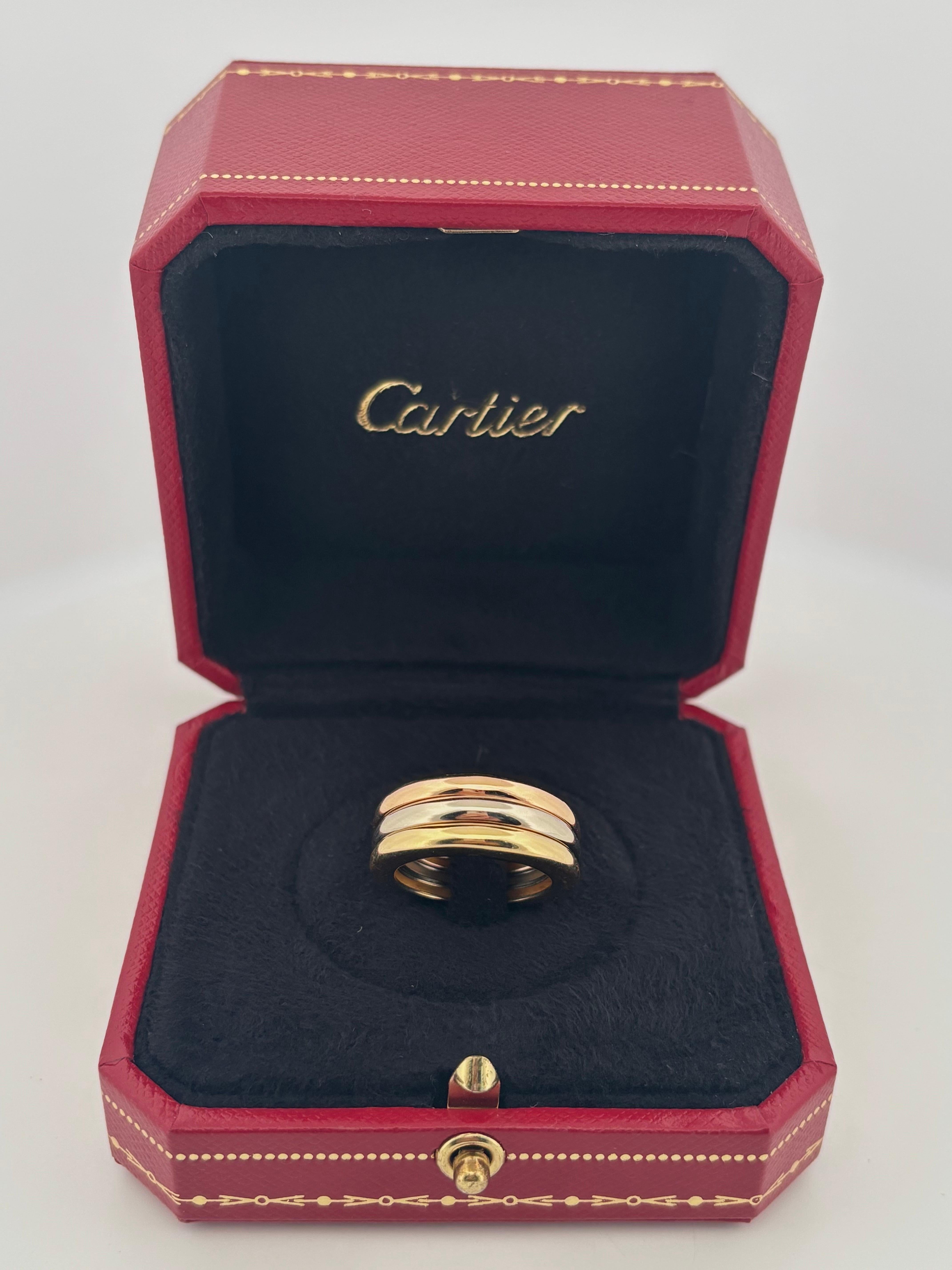 Dieser Cartier Trinity Stacking Ring ist ein Symbol für zeitlose Eleganz und Luxus. Das aus massivem 18-karätigem Dreifarbgold gefertigte Design zeigt ineinander greifende Bänder aus Gelb-, Weiß- und Roségold, die für Liebe, Treue und Freundschaft