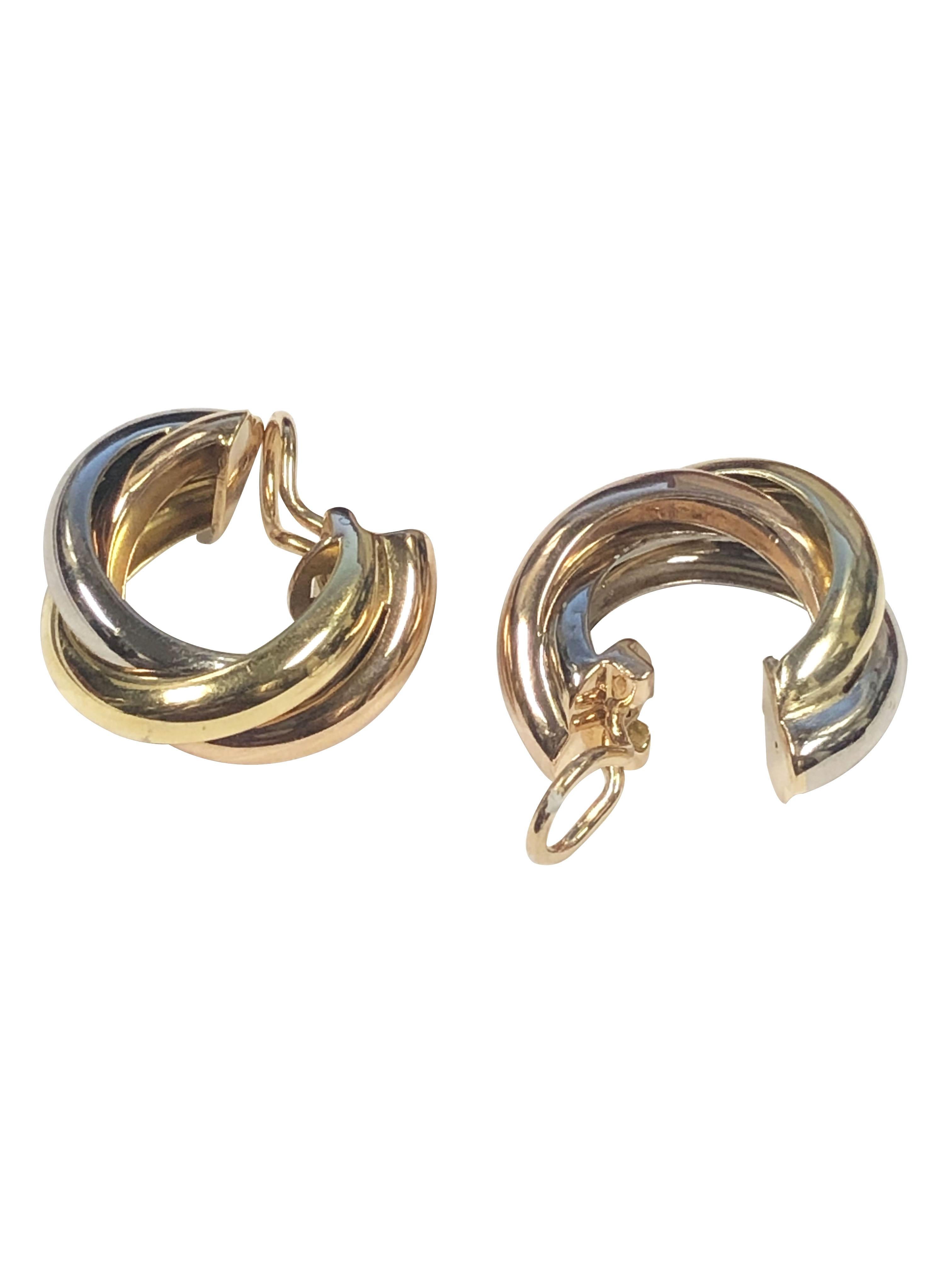 Circa 2000 Cartier Trinity collection 18K Yellow, Rose and White Gold Hoop Earrings, measuring 7/8 inch in length 7/8 inch in diameter and 3/8 inch wide. having Omega backs to which a post can be easily added if desired. Comes in the original