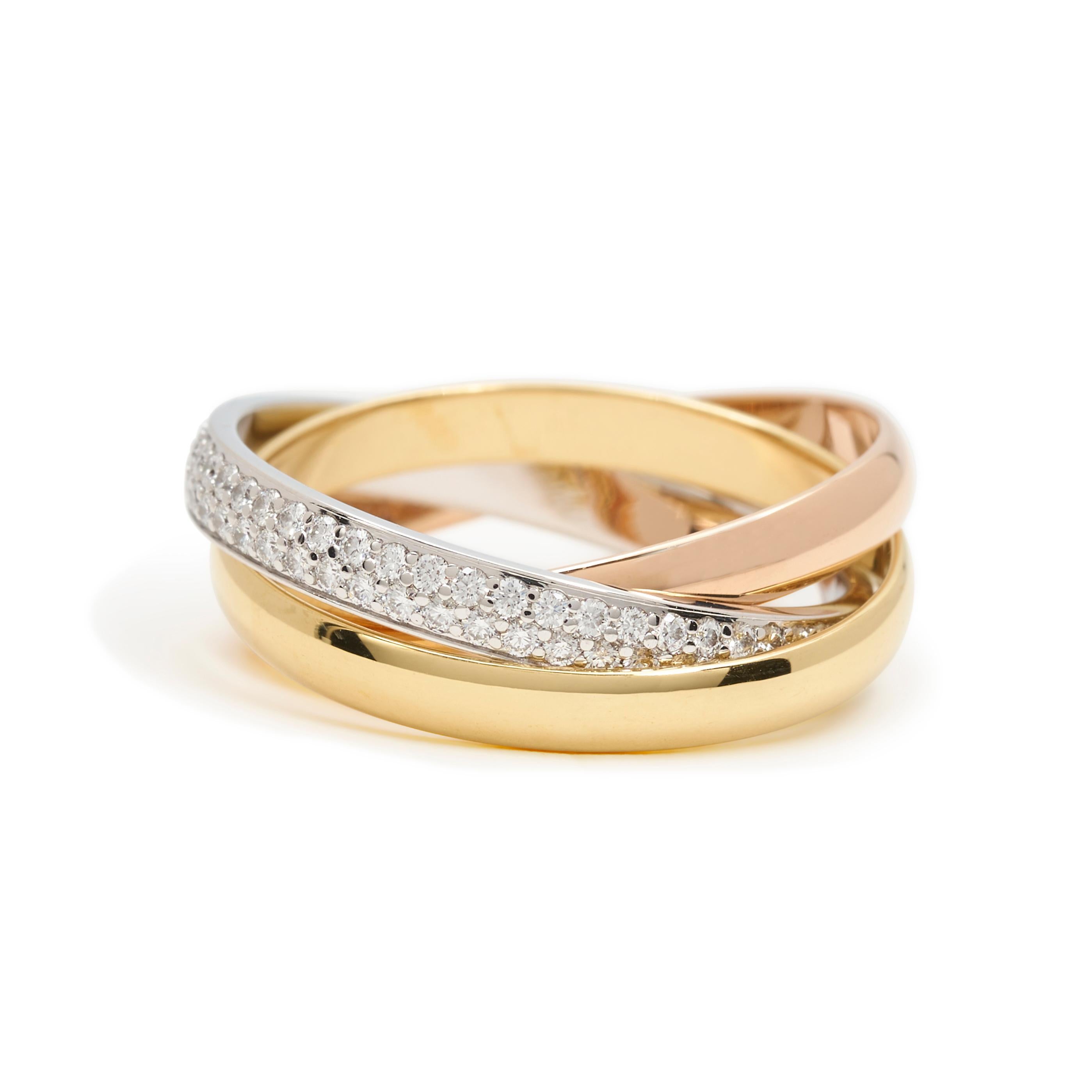 Authentic Cartier Trinity ring comprised of three interlocking mobile bands of 18 karat yellow, rose, and white gold.  The white gold band is encrusted with an estimated 0.46 carats of high-quality brilliant-cut diamonds.  Size 54, US 6 3/4.  Signed