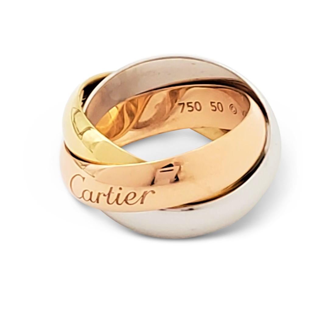 Authentic Cartier 'Trinity' ring comprised of interlocking bands of 18 karat yellow, rose, and white gold. Signed Cartier, Au 750, 50, with serial number. Ring size 50 (US 5 1/4). Each band measures 5 mm wide. Not presented with the original box or