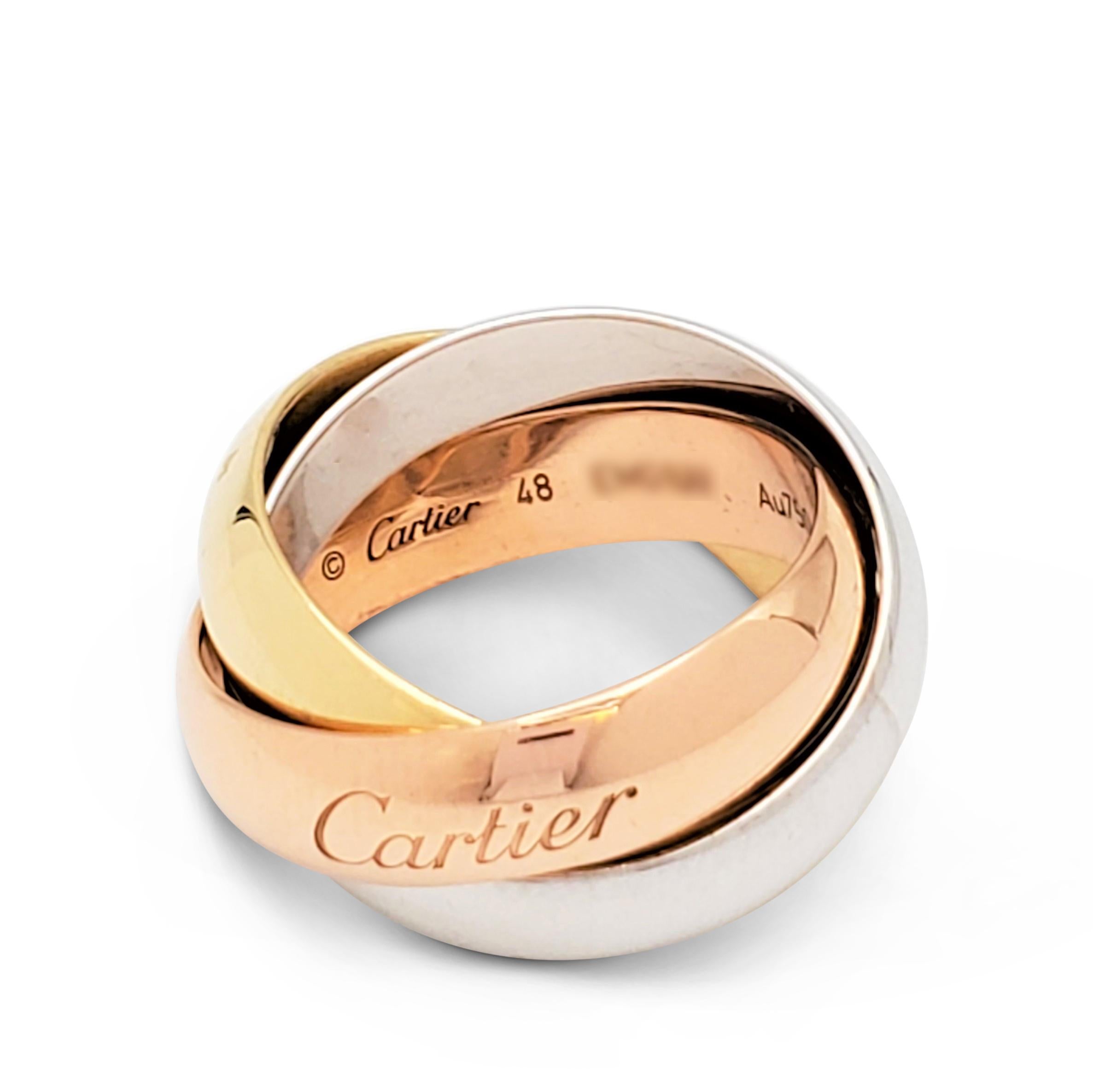 Authentic Cartier 'Trinity' ring comprised of interlocking bands of 18 karat yellow, rose, and white gold. Signed Cartier, Au 750, 48, with serial number. Ring size 48 (US 4 1/2). Each band measures 5.0 mm wide. Presented with the original box, no