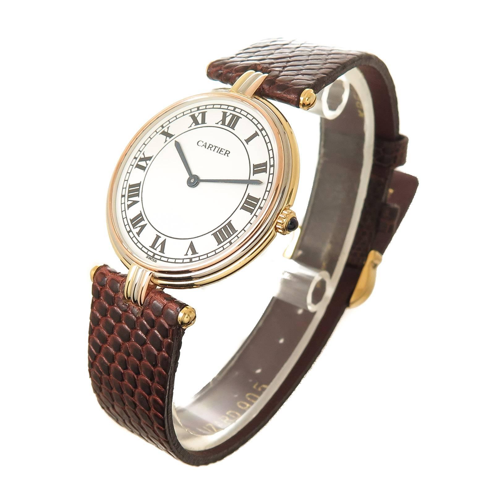 Circa 1990s Cartier 18K Yellow, White and Rose Gold Trinity Watch. 2 piece 30 MM water resistant case, Quartz Movement, White Dial with Black Roman Numerals and a Sapphire set crown. New Brown Lizard strap with a Gold Plate Cartier Tang Buckle.