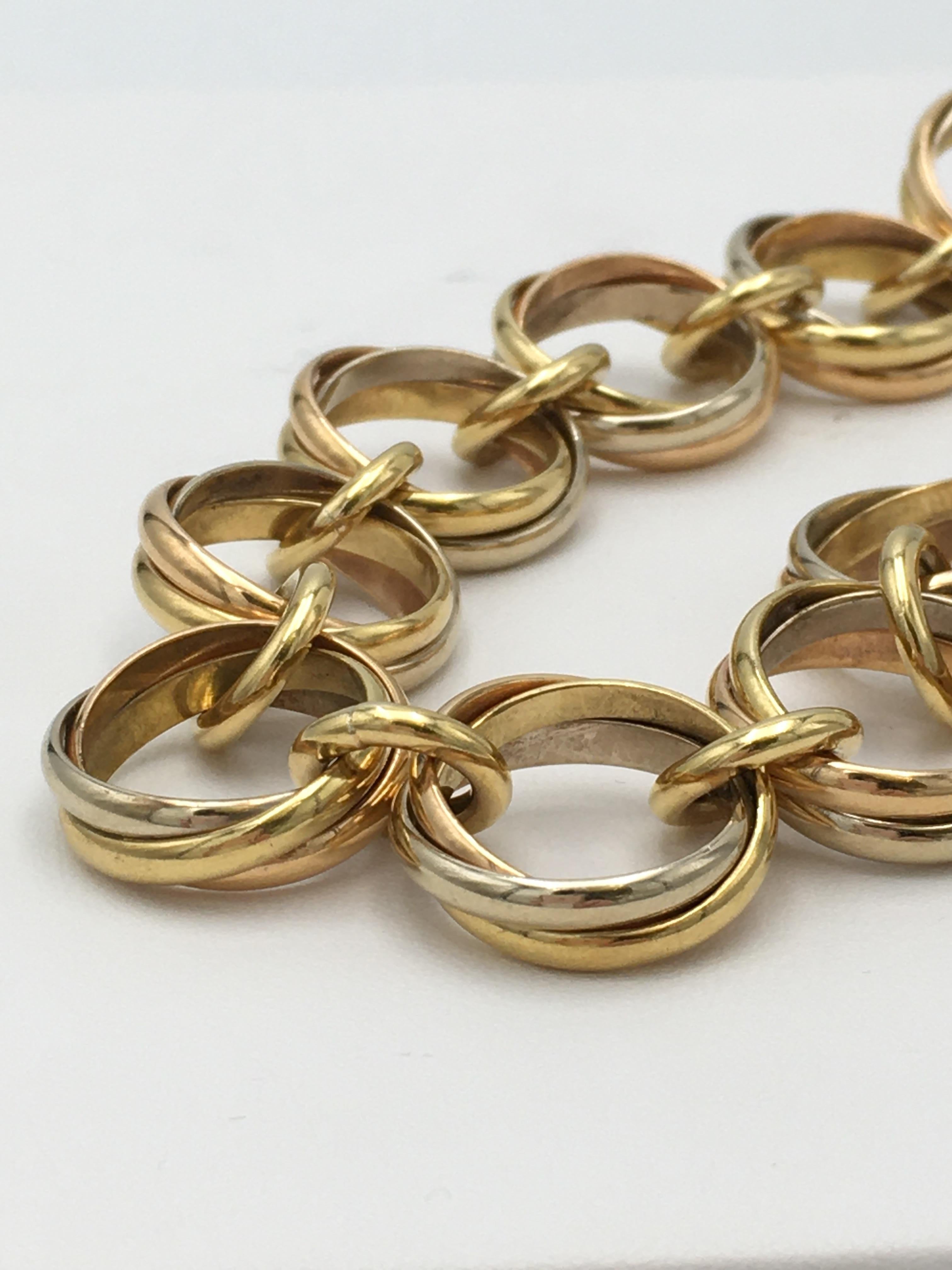 Authentic Cartier 'Trinity' link bracelet comprised of interlocking rings of 18 karat yellow, rose, and white gold. Signed Cartier, 750, Cartier 1991, with serial number. The bracelet measures 7 3/4 inches in length. Not presented with original box