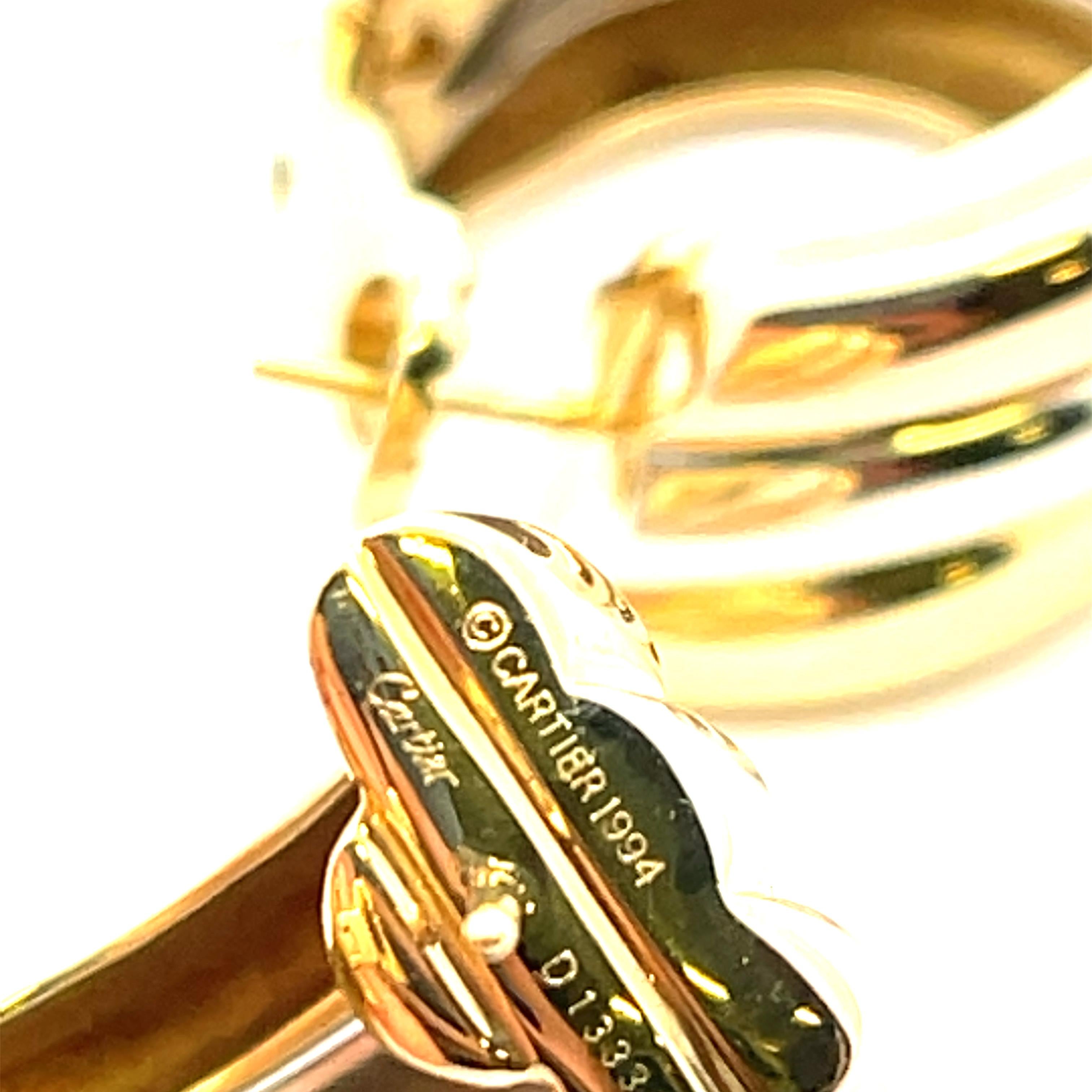 Estate Cartier Trinity Tri-Gold Hoops in 18K Gold. The earrings measure approximately 1 inch by 1/2 inch and weigh 35.5 grams. Stamped Cartier 1994.