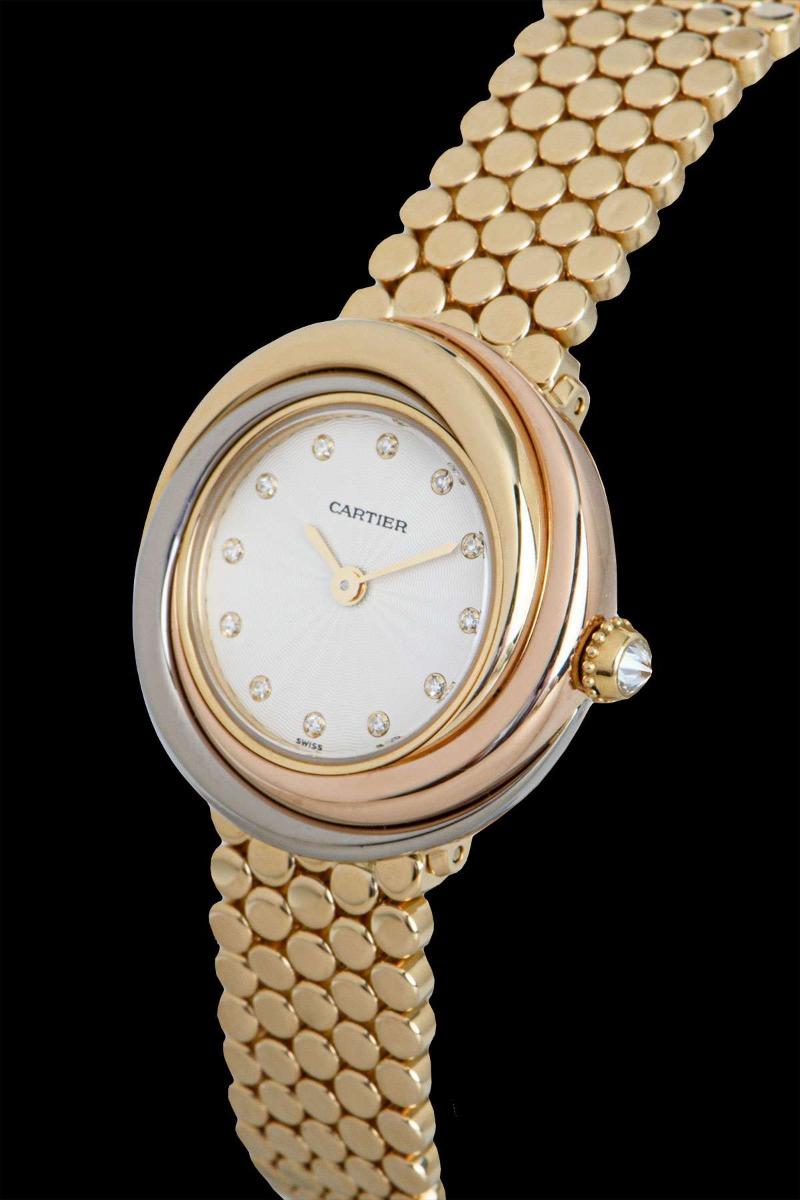A 27 mm Trinity women's wristwatch, with a diamond set silver dial and a diamond set crown. 

The quartz wristwatch is in excellent condition. It features a fixed 18k tri-gold bezel and case, an 18k yellow gold jewellery style bracelet, a concealed