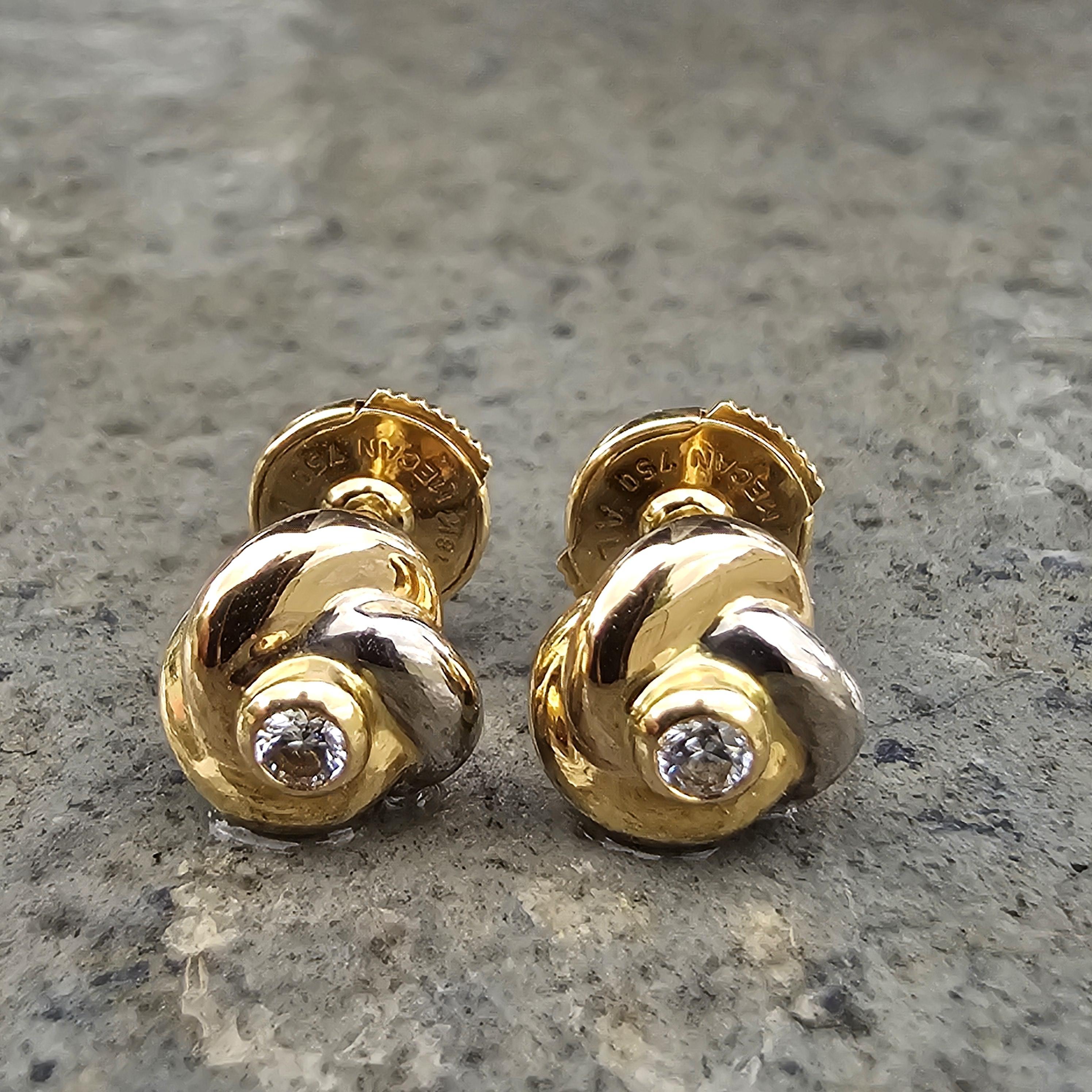 Elevate your jewelry collection with these exquisite Cartier stud earrings. Crafted with precision, these earrings feature a captivating knot design in luxurious 18k gold. Each earring is adorned with a brilliant white diamond at its center, adding