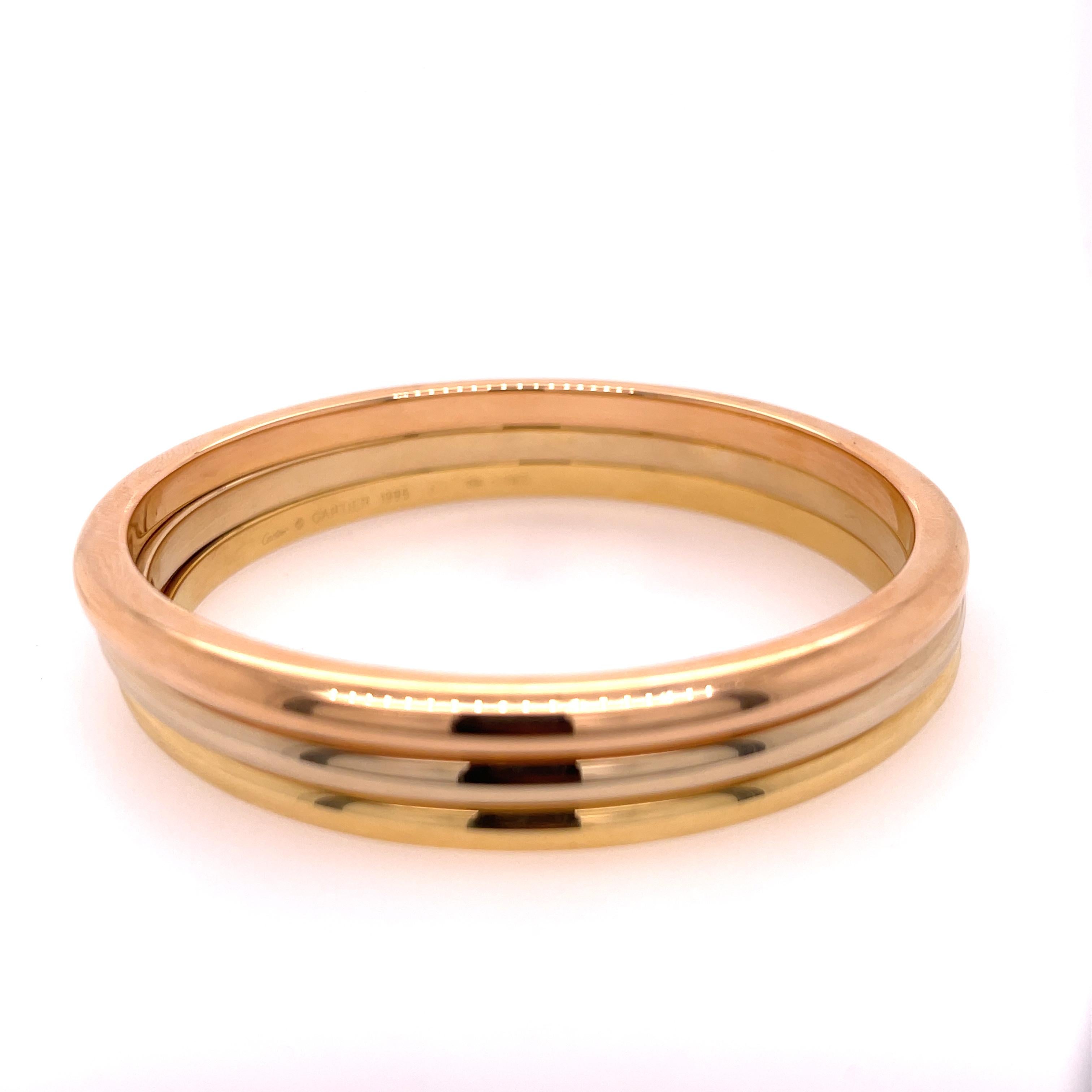 Three bangles in one by Cartier in 18K rose, white, and yellow gold.  The bangle has a inner diameter of 7 inches. Stamped Cartier 1995 60 750.