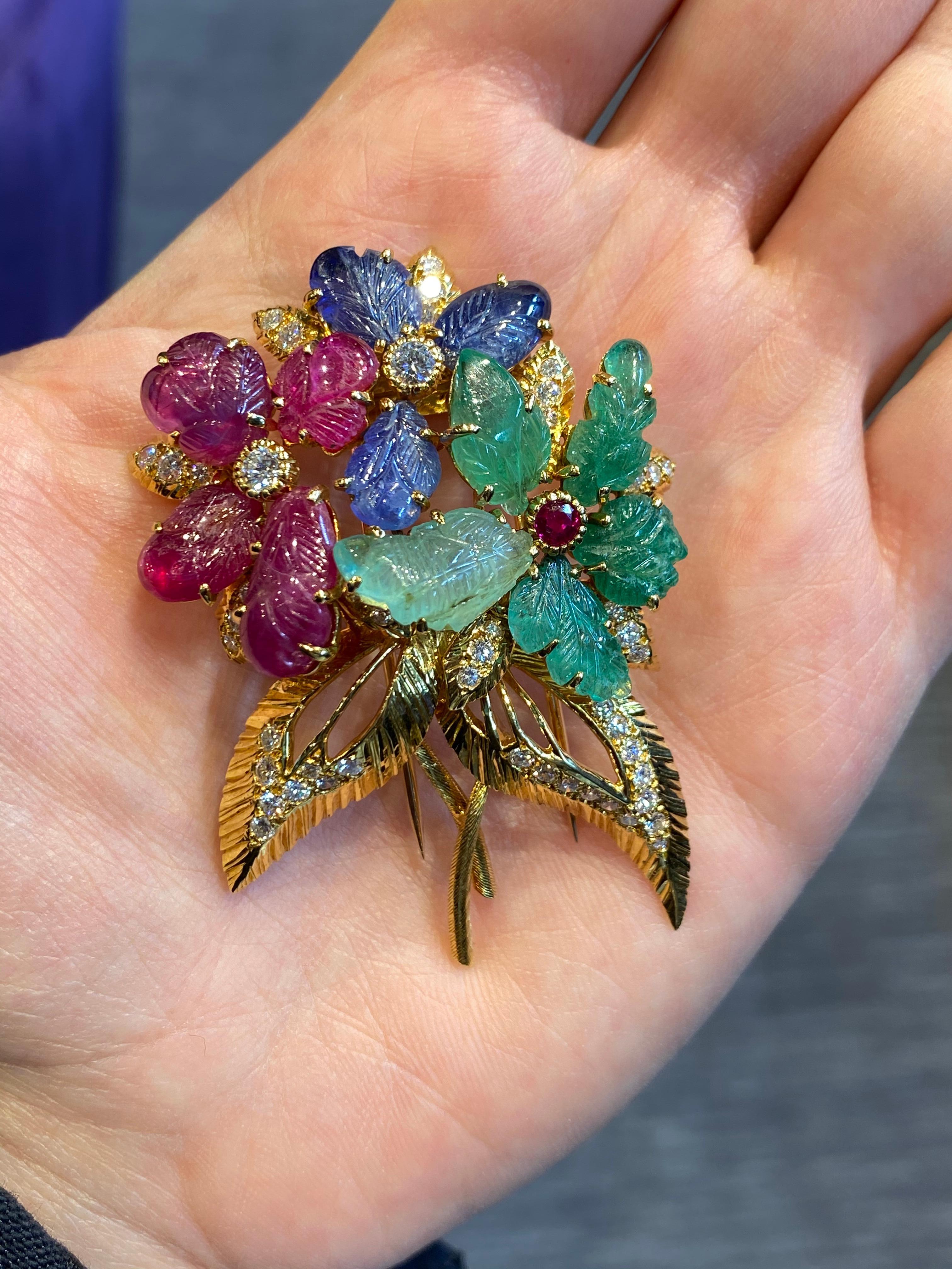 Cartier Tutti Frutti Flower Brooch

Made Circa 1953

Carved sapphires, emerald, and rubies accented with diamonds.

18K yellow gold  Signed Cartier, Paris, numbered, with Cartier maker's mark.

Measurements: 2 3/8 x 1 3/4 inches.