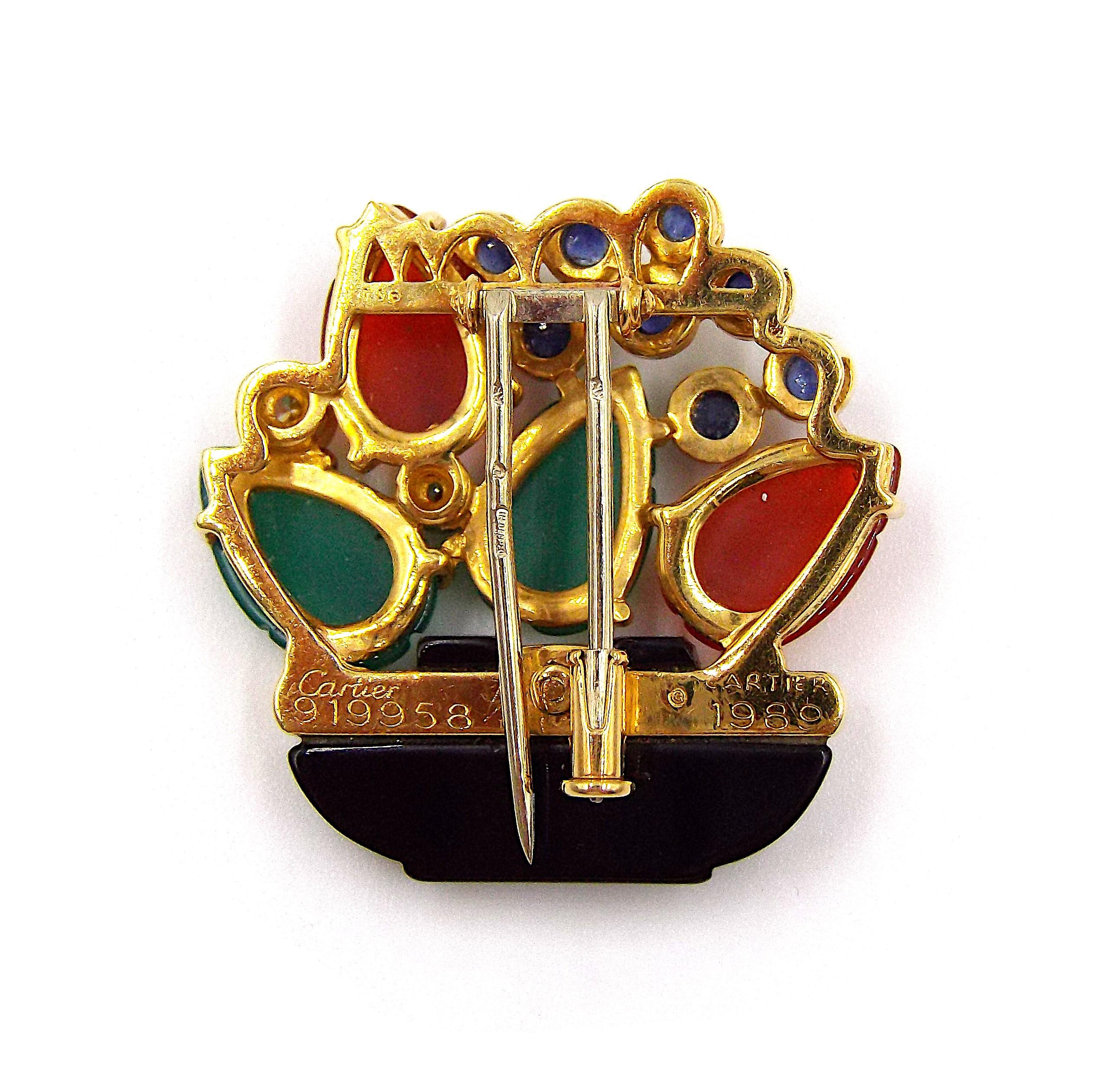 Eine ausgefallene Brosche von Cartier in Form eines bunten Blumenkorbs mit geschnitzten Rubinen, Smaragden, Onyx, Cabochon-Saphiren und zahlreichen runden Diamanten. Abmessungen: 1 1/8