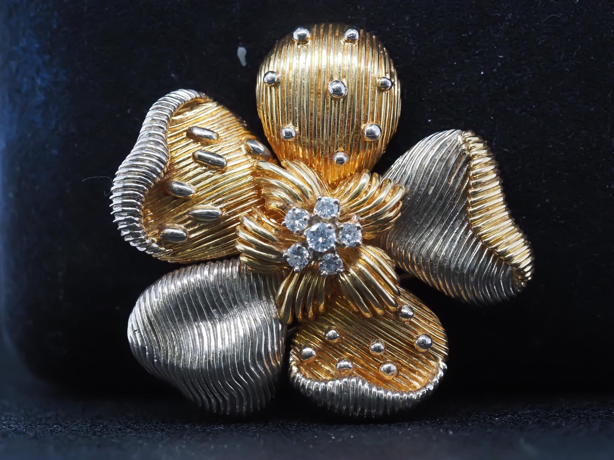 Cartier Two Tone 18K Gold and Diamond Flower Brooch
Item Details:
Metal Type: 18K Yellow Gold [Hallmarked, and Tested]
Weight: 34.4 grams

Diamond Details: .50ct total weight, F Color, VS Clarity, Round Brilliant.

Pin Measurements:
Length: 1.75