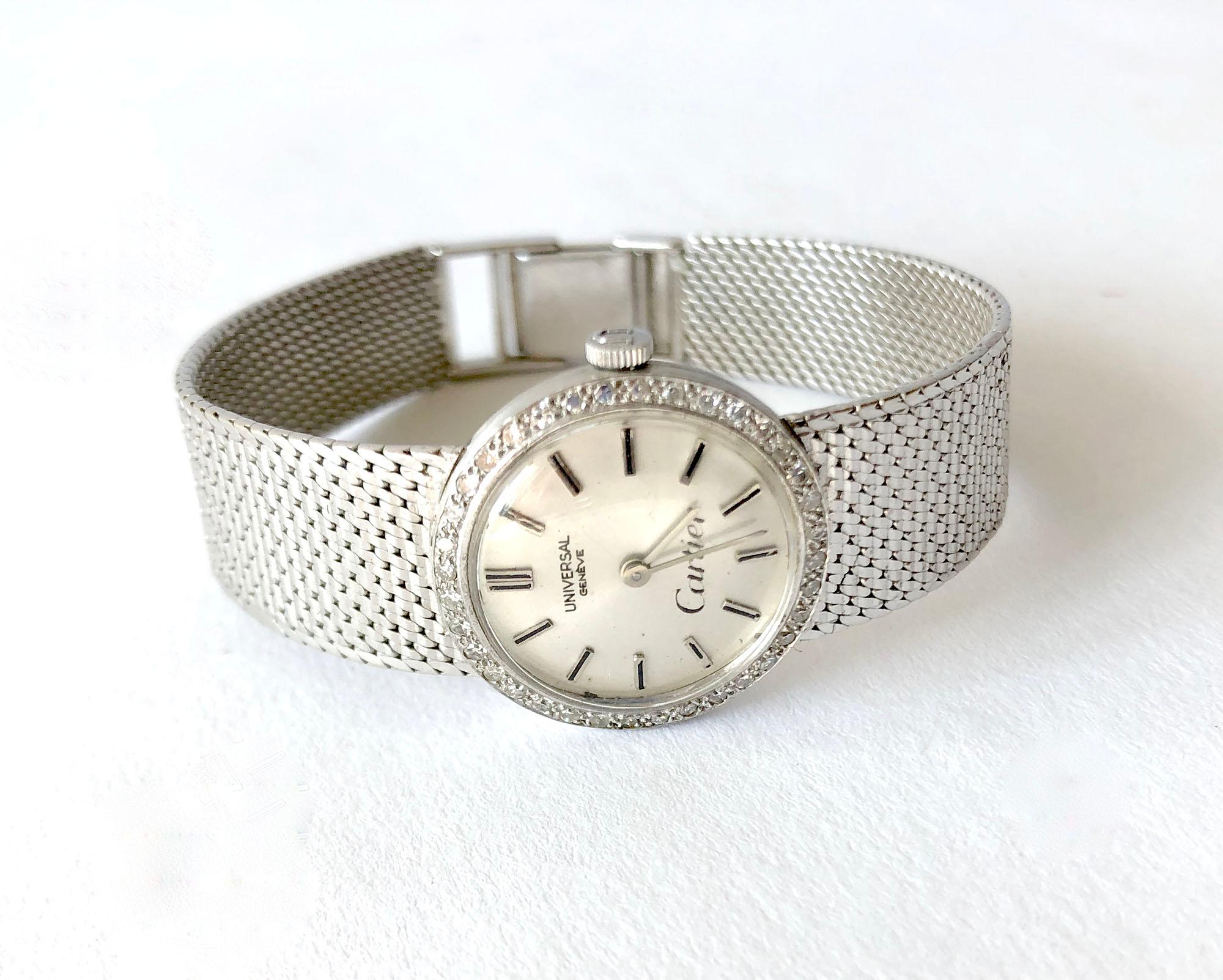 Vintage 1950s 18K white gold mesh ladies Universal Genéve wrist watch with diamond surrounded dial by Cartier.  White gold mesh bracelet is made for a small wrist and measures 6 1/8